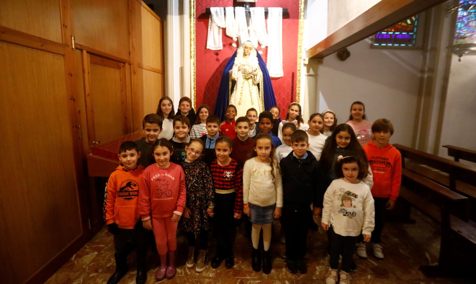 Niños que conforman la Escolanía San Francisco de Asís, ante la Virgen de la Soledad.