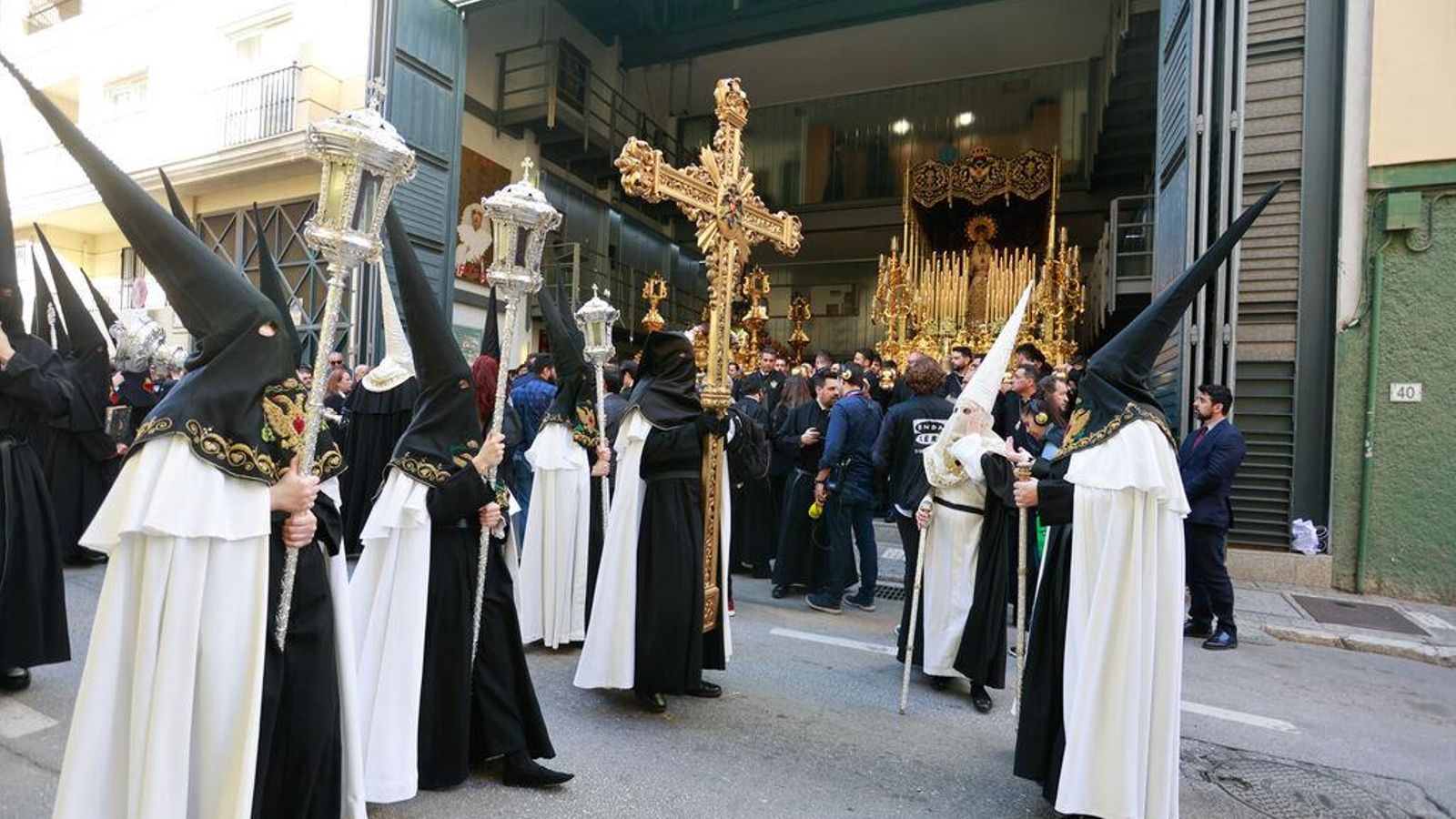 La cruz guía pasa por delante de la casa hermandad con la Virgen de la Caridad al fondo. La cruz guía pasa por delante de la casa hermandad con la Virgen de la Caridad al fondo.