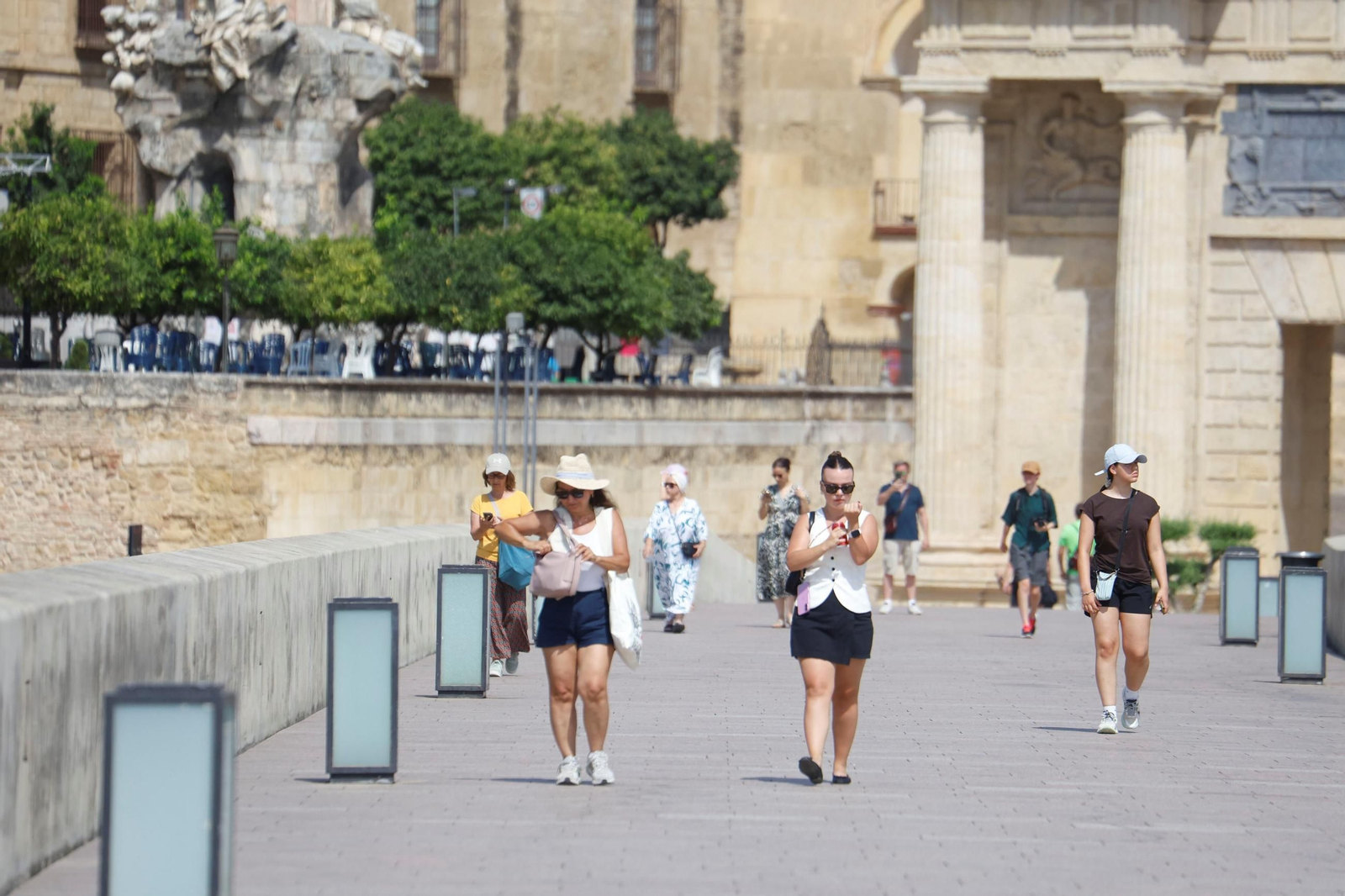 Un grupo de personas caminando por el Puente Romano.