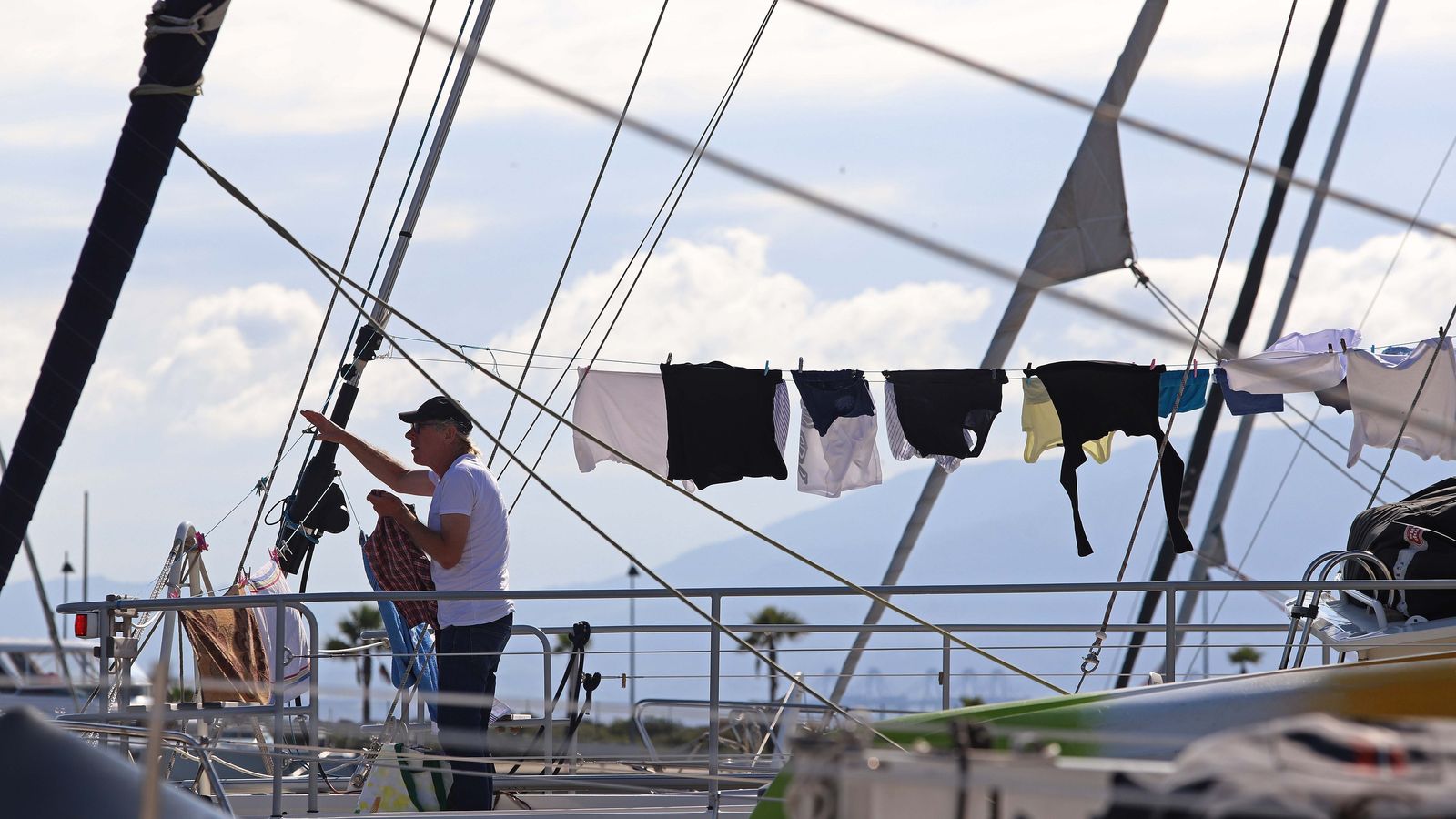 El propietario de una de las embarcaciones seca ropa al sol.