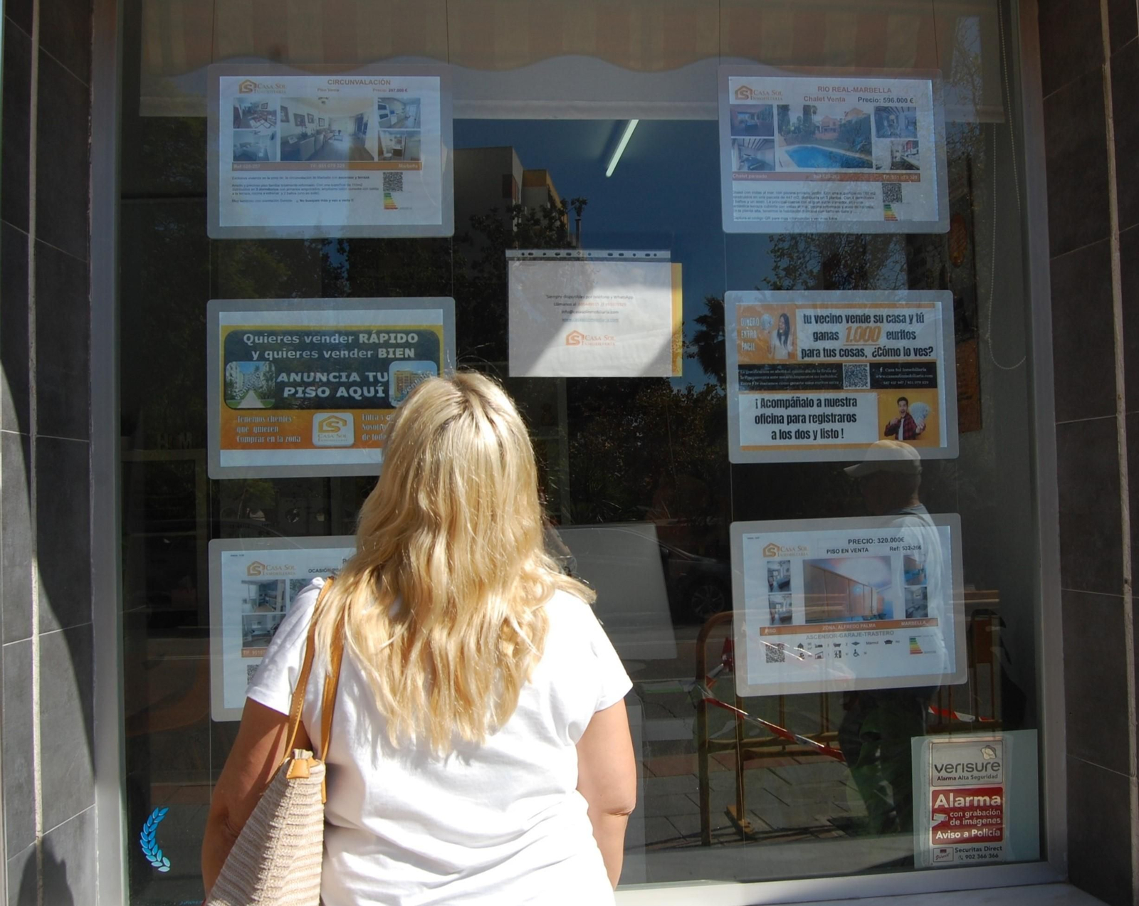 Una mujer mirando las ofertas de pisos.