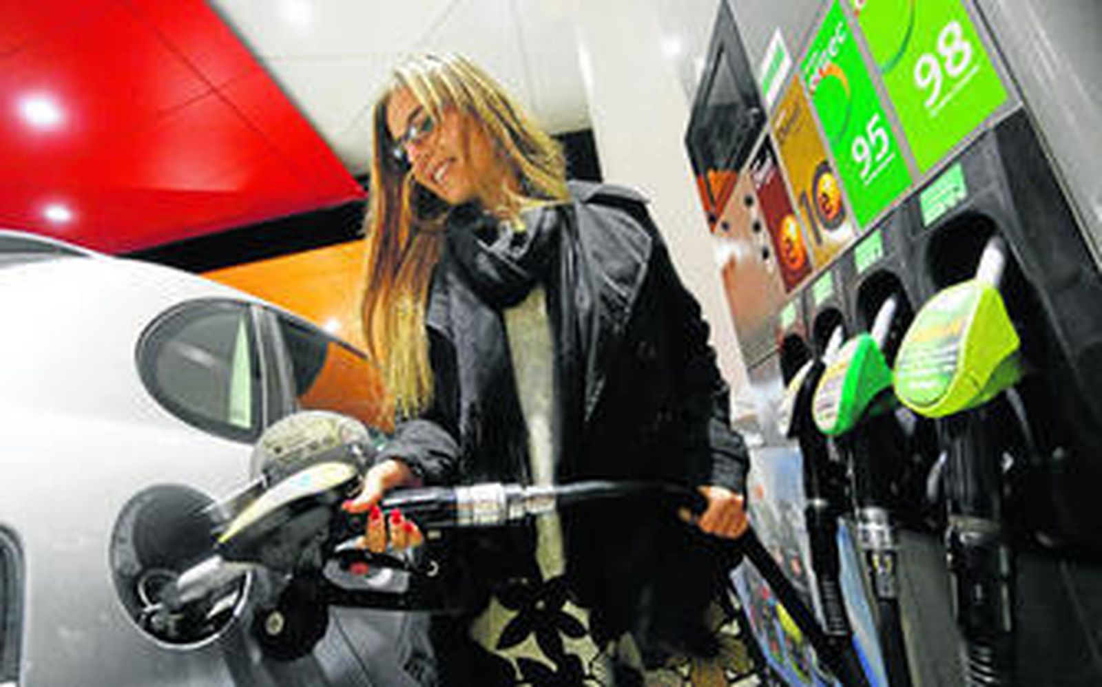 Una cliente echa gasolina en una estación de servicio.