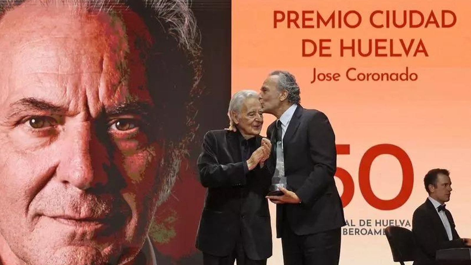 José Coronado besando en la sien a Jose Luis Ruiz tras recoger el Premio Ciudad de Huelva del Festival de Cine.