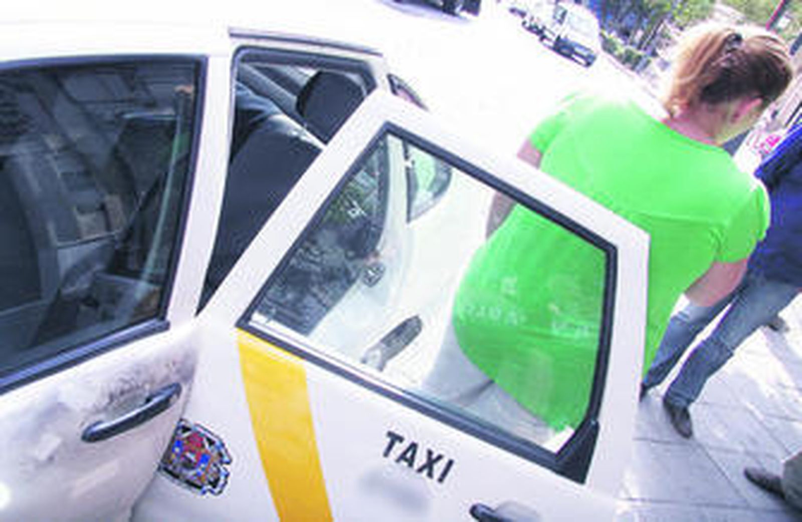 La conductora atracada, ayer junto a su taxi.