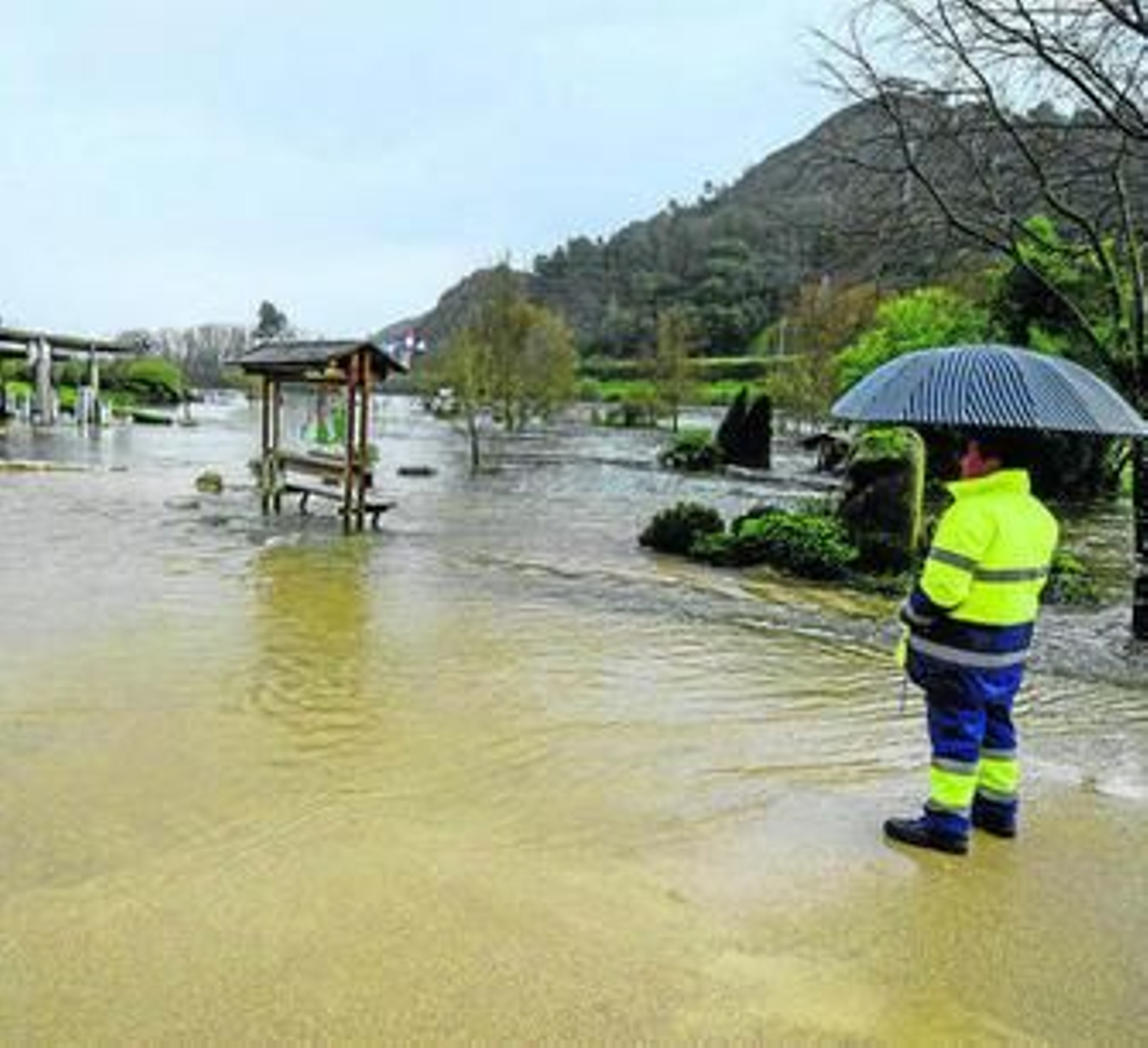 Un hombre observa las termas de Outariz, Orense, completamente anegadas por la crecida del Miño.