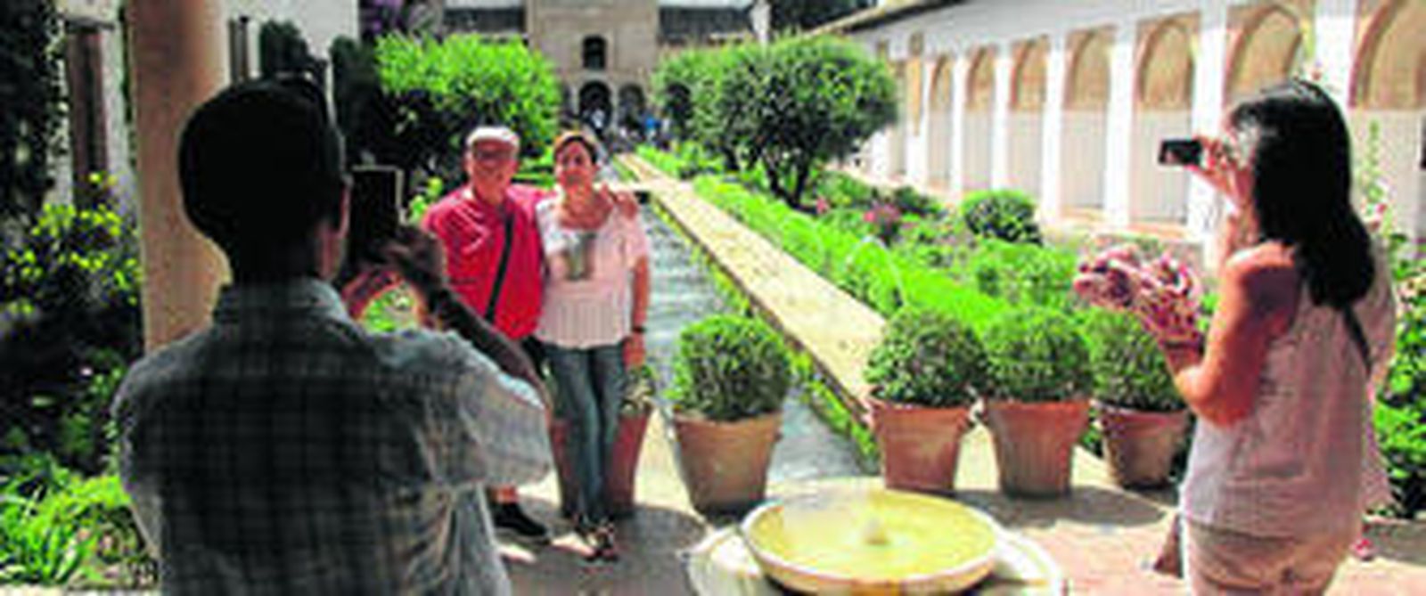 Varios turistas en el patio de las Acequias.