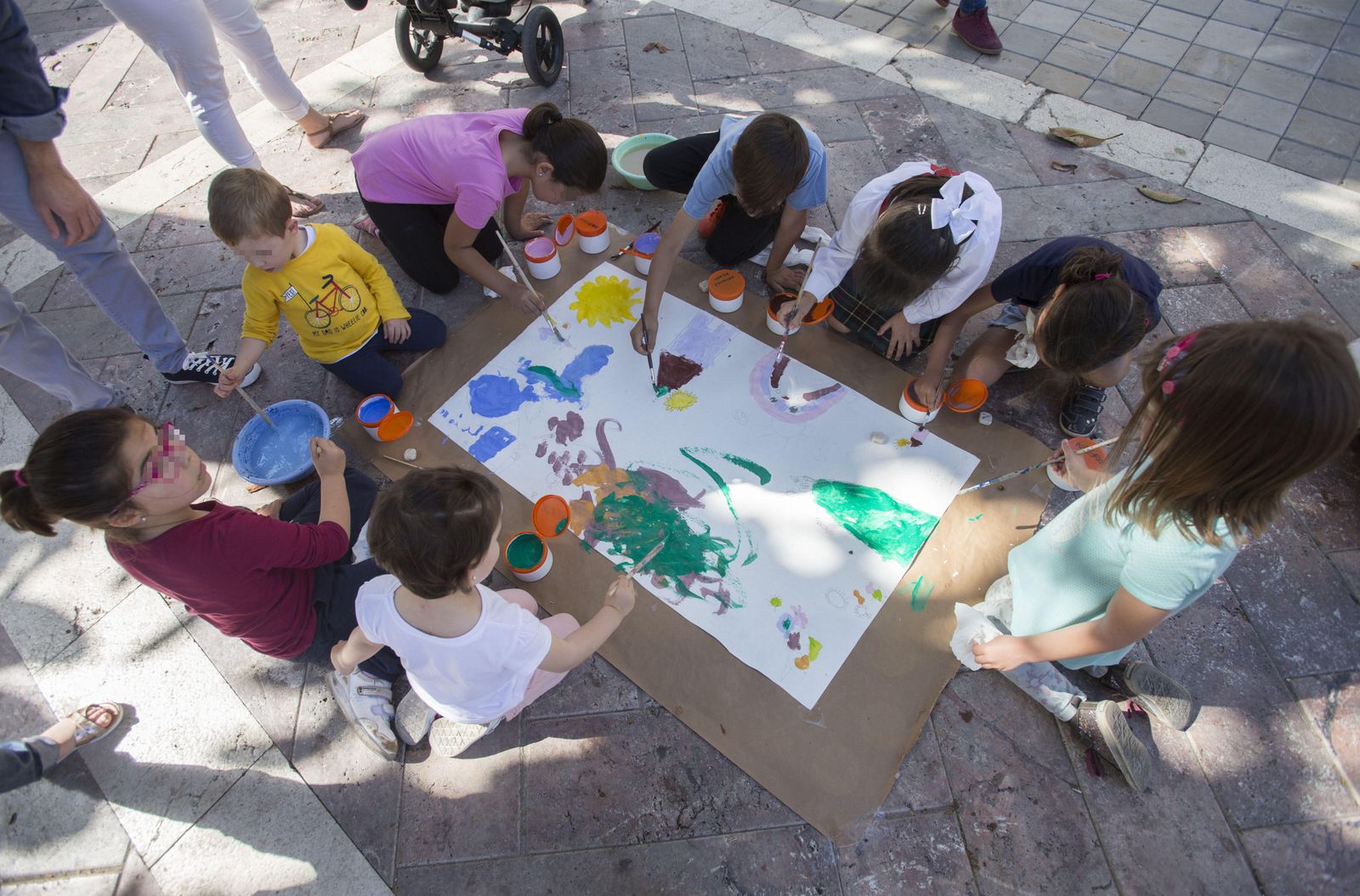 Varios niños pintan un mural en la Plaza de las Monjas para fomentar el 'Derecho a jugar y expresarse libremente'.