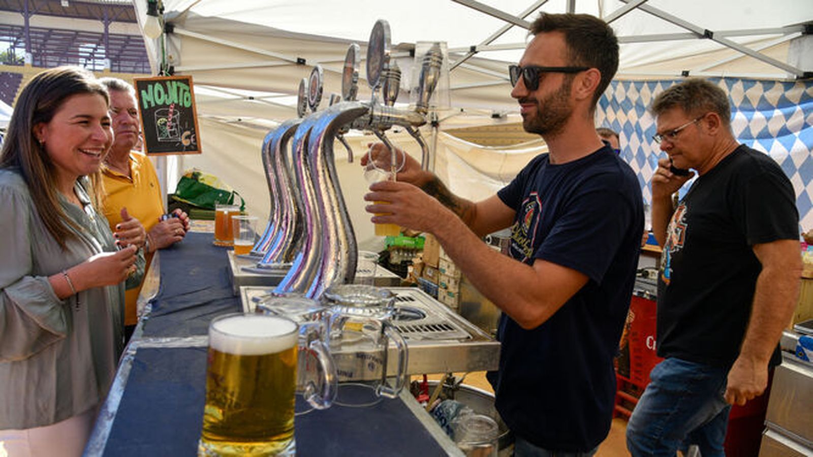 Un camarero sirve una cerveza en un Oktoberfest de La Línea.
