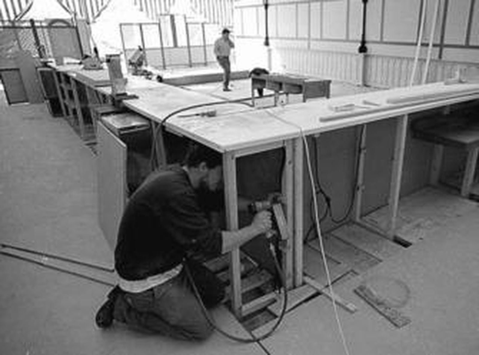 Un trabajador monta una barra en una caseta del Real de la Feria.