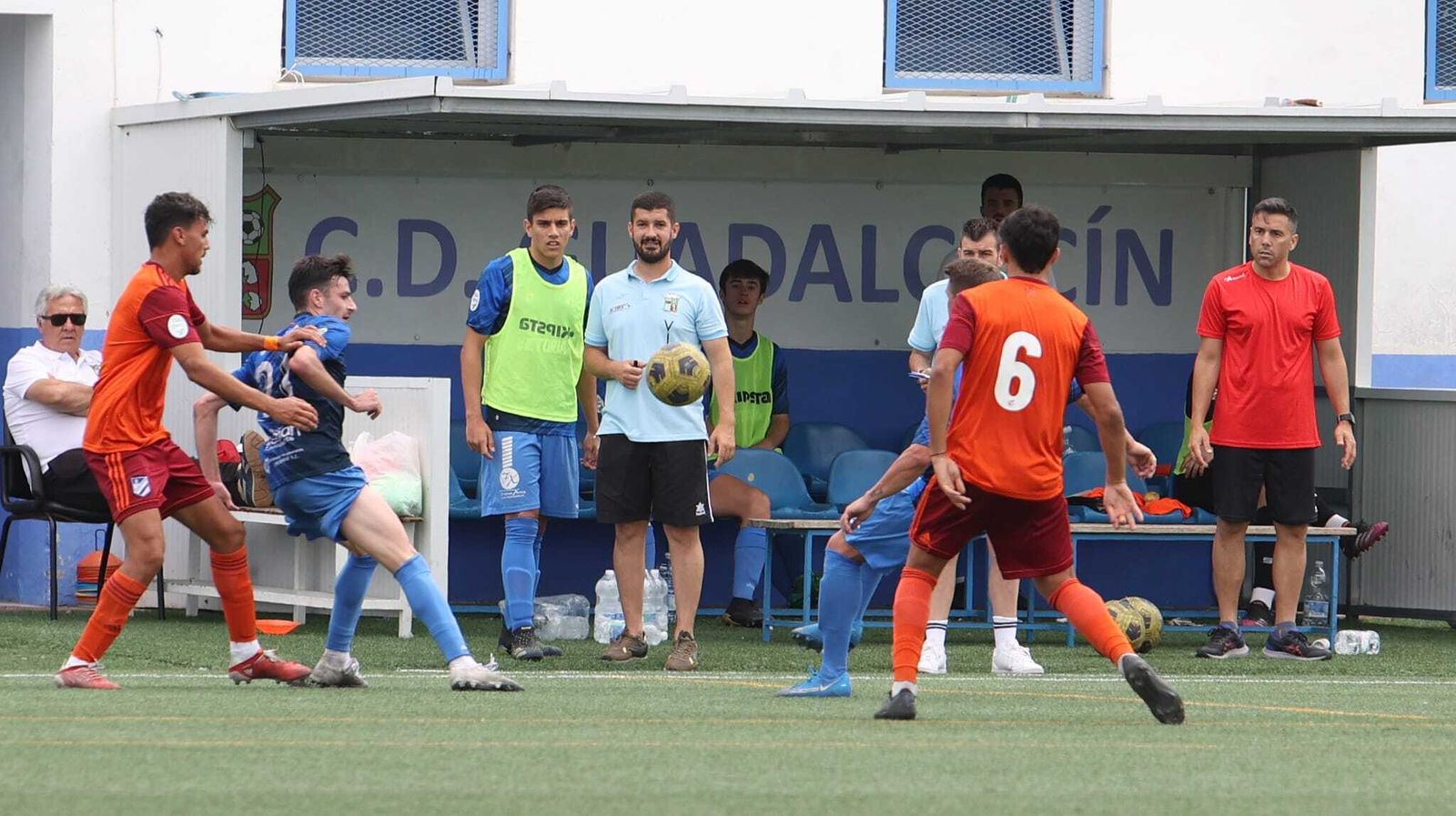 Paco Ávila charla con un jugador antes de realizar un cambio.