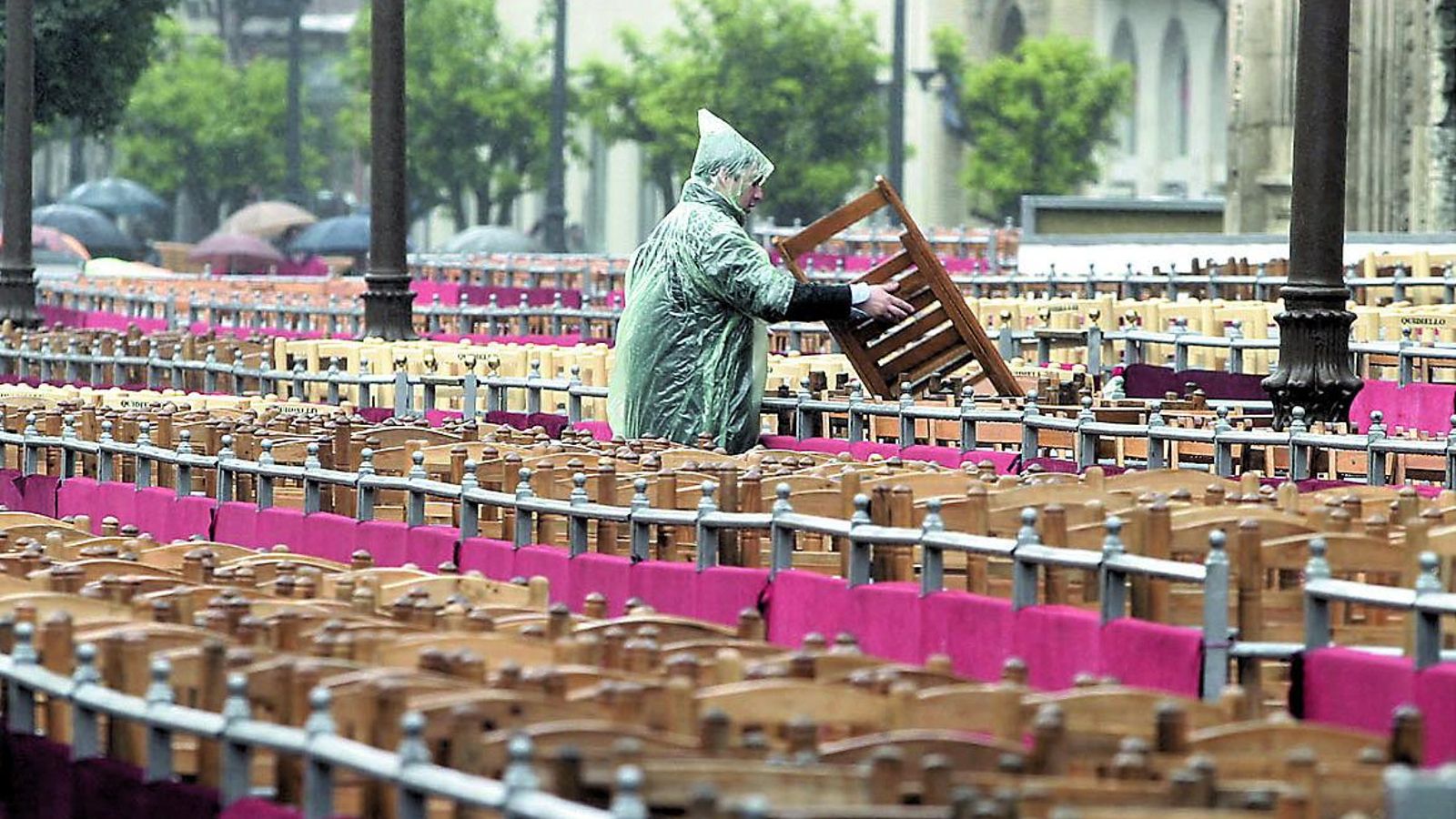 Colocación de sillas en la carrera oficial un día lluvioso.