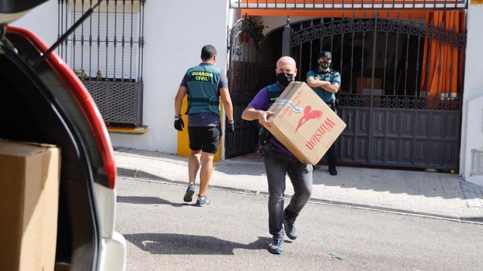 Los agentes sacan las cajas de tabaco del interior de una de las viviendas registradas en la provincia de Sevilla.
