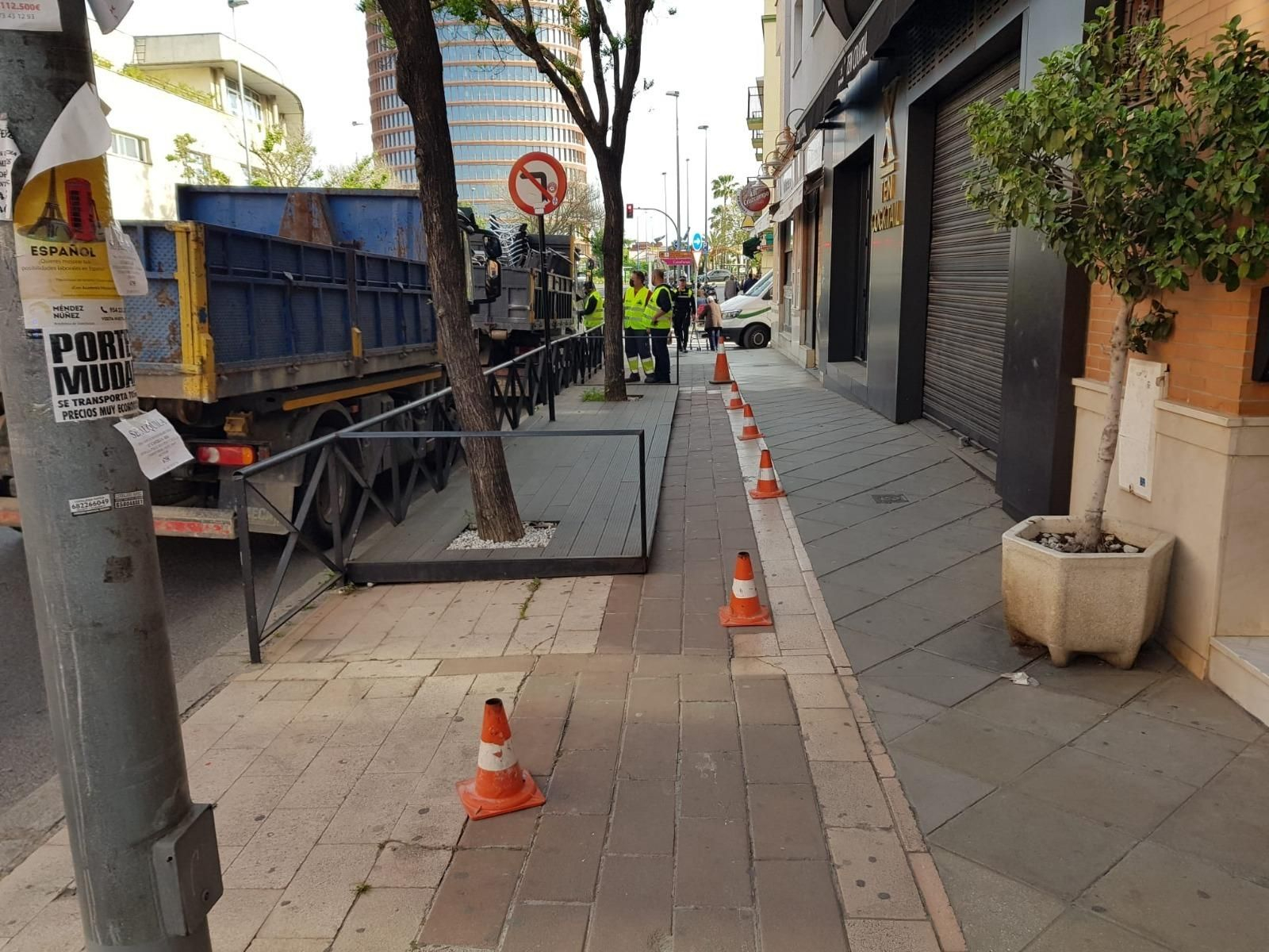 Varios operarios observan el mobiliario retirado de un bar enclavado en la Ronda de Triana.