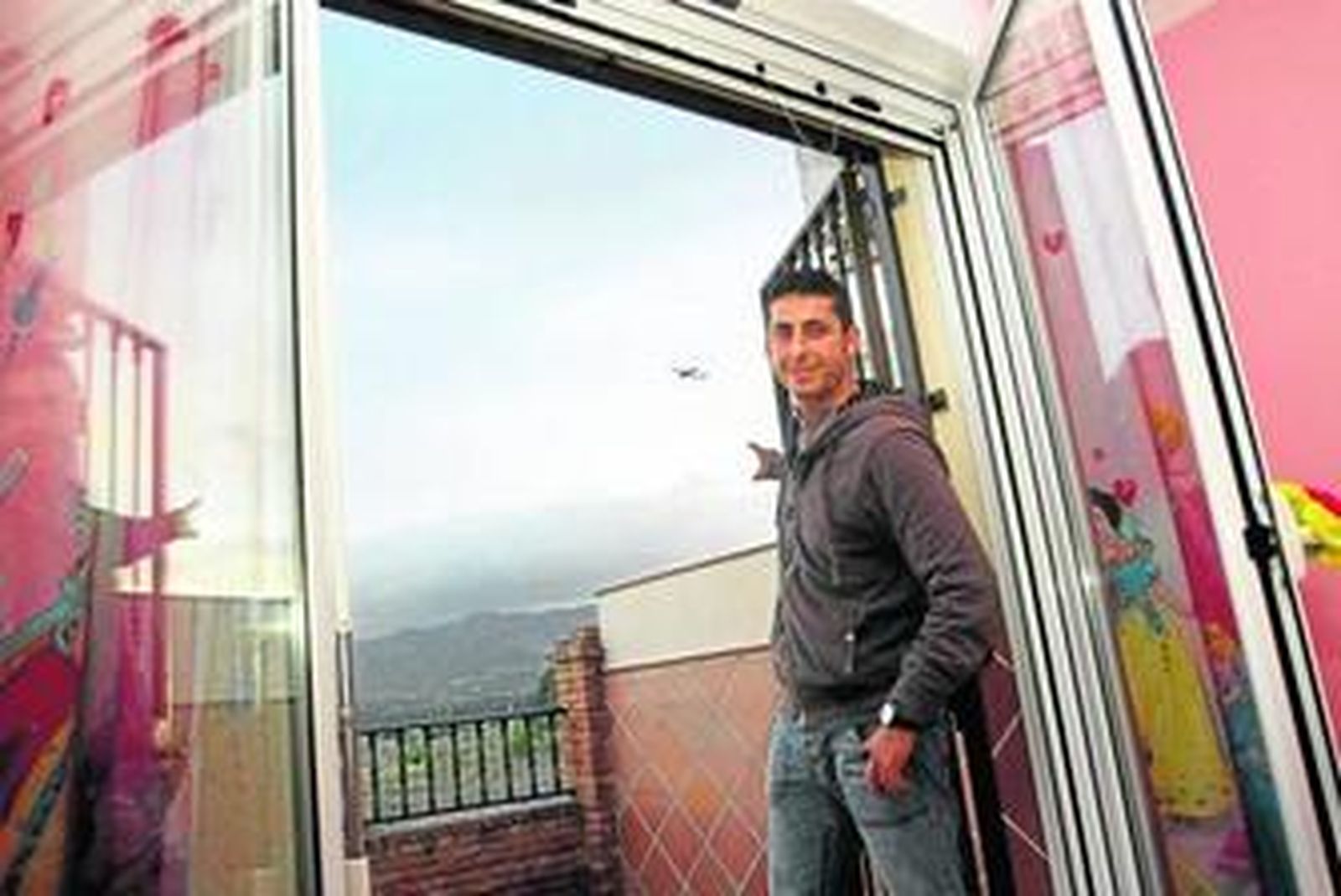 Carlos Fernández muestra el paso de un avión desde una de las habitaciones de su casa en San Julián.