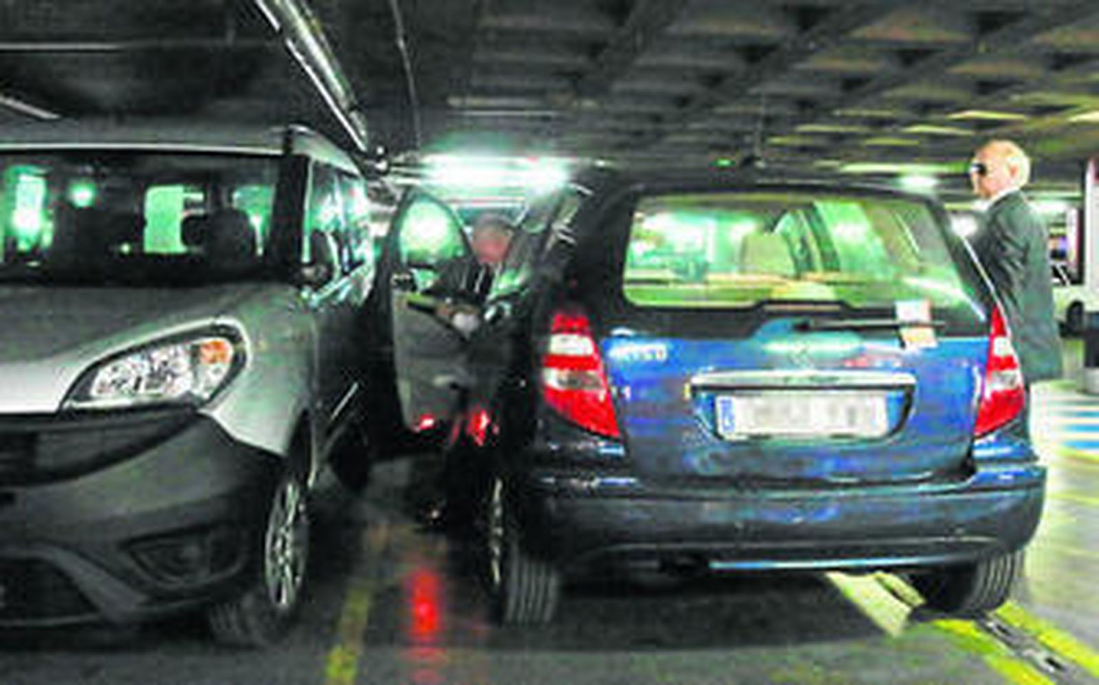 Un conductor intenta salir de su coche con bastante dificultad.