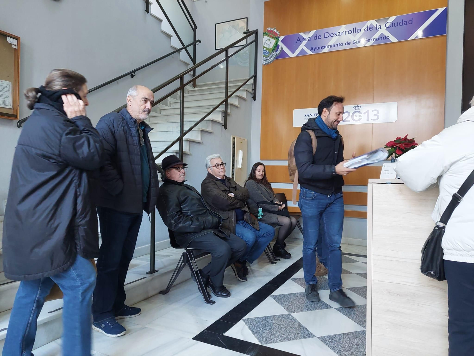 Representantes de los vecinos y su abogado, a la espera de ser atendidos en Urbanismo.