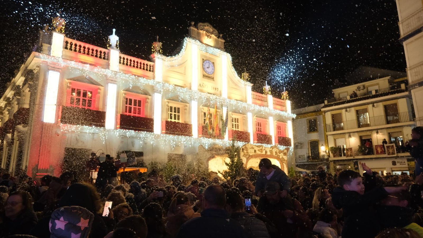 Cabra Cientos de personas disfrutan con la nevada ante el Ayuntamiento de Cabra, ya iluminado.