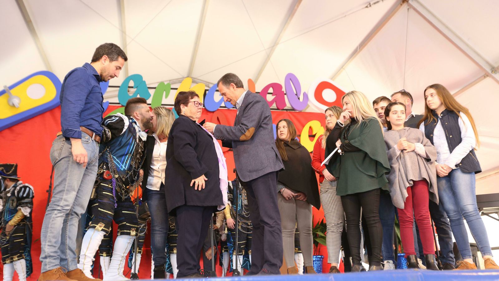 El alcalde coloca la Insignia de Oro del Carnaval a la viuda de 'El Parri'.