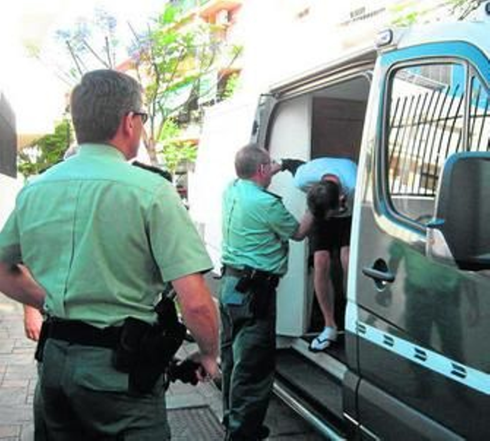 Agentes de la Guardia Civil bajan del furgón al detenido, ayer, en los juzgados de Mijas.
