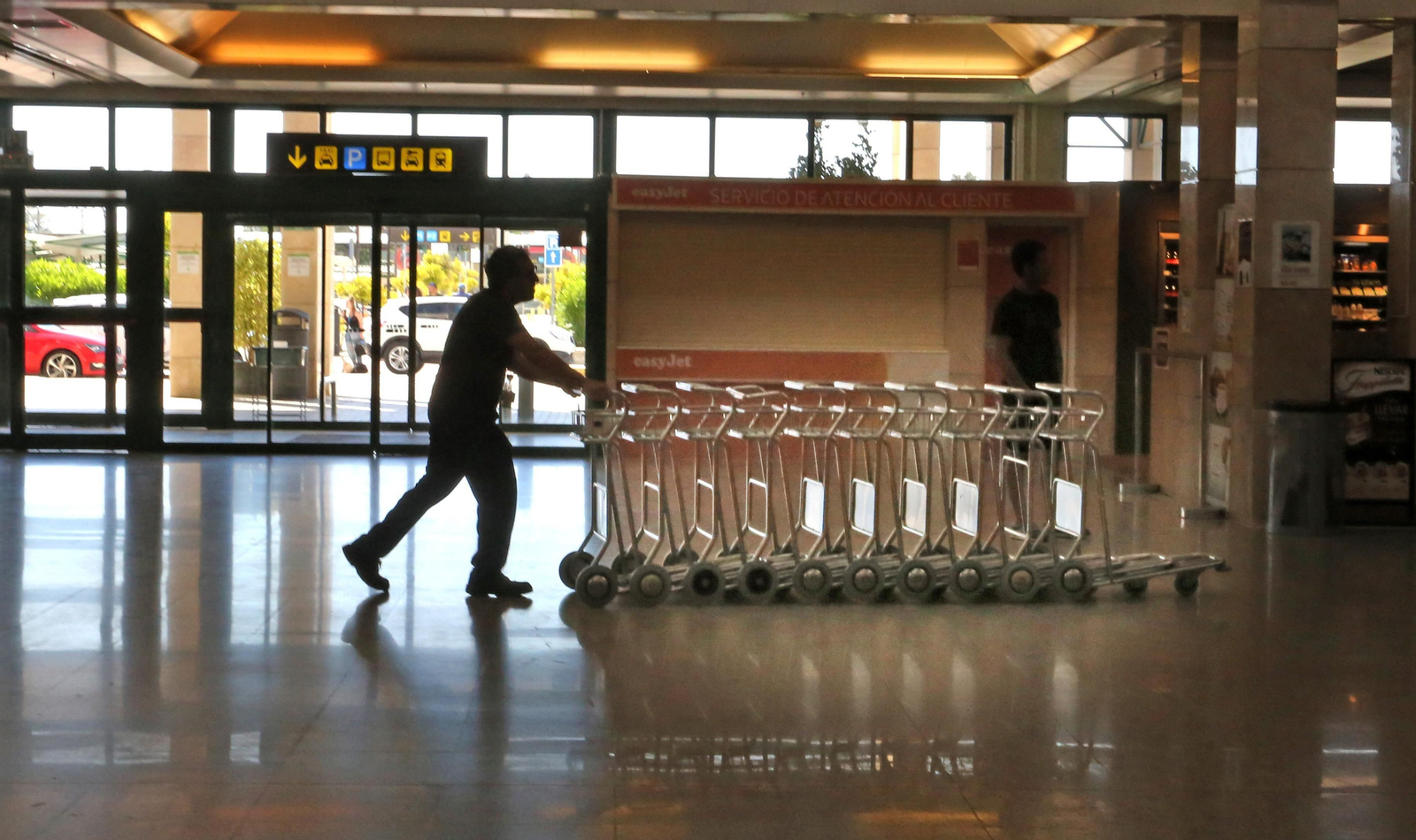 Un operario empuja carros para equipaje en el aeropuerto de Jerez.