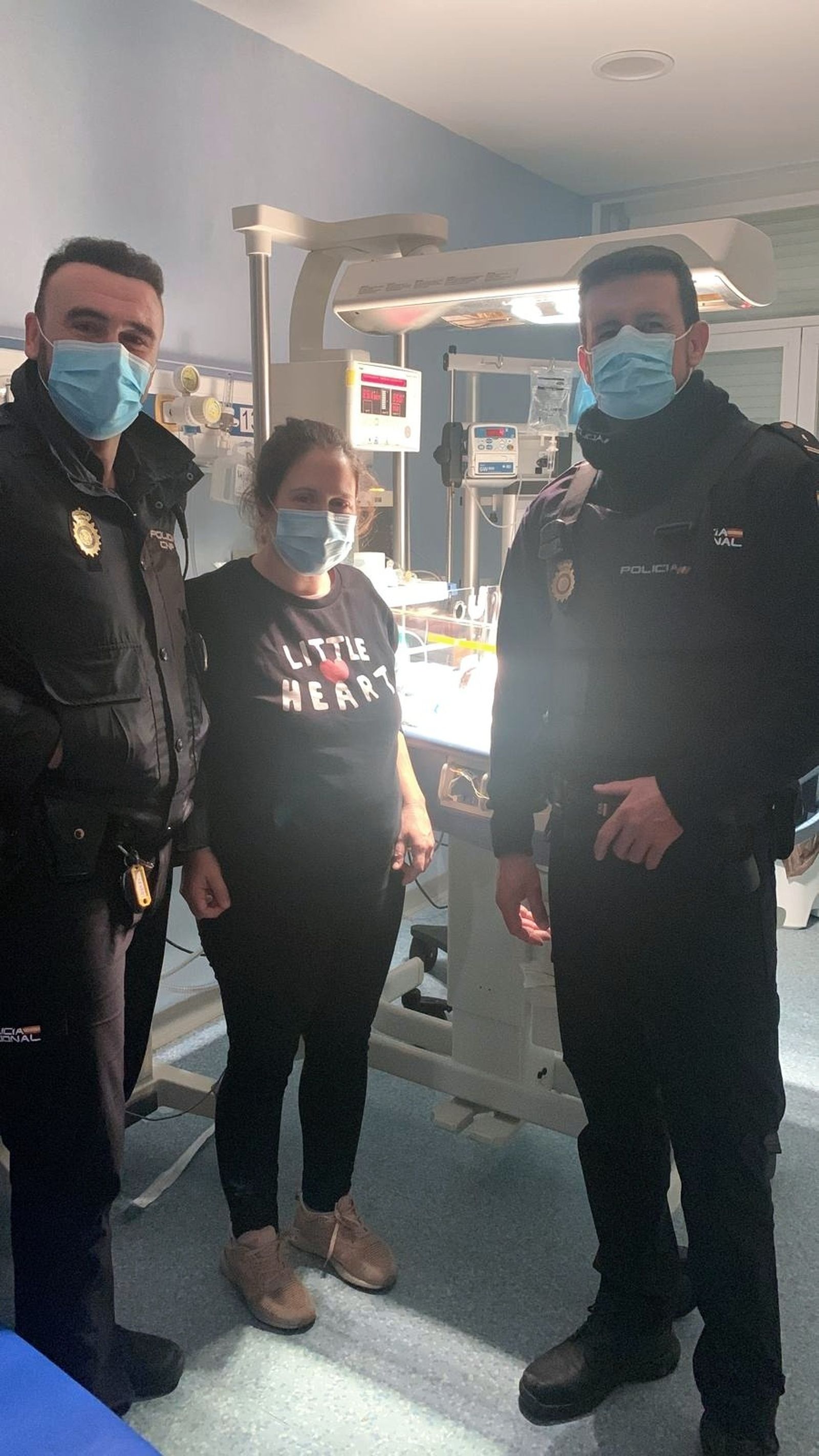 La madre de la bebé con los dos agentes de la Policía Nacional