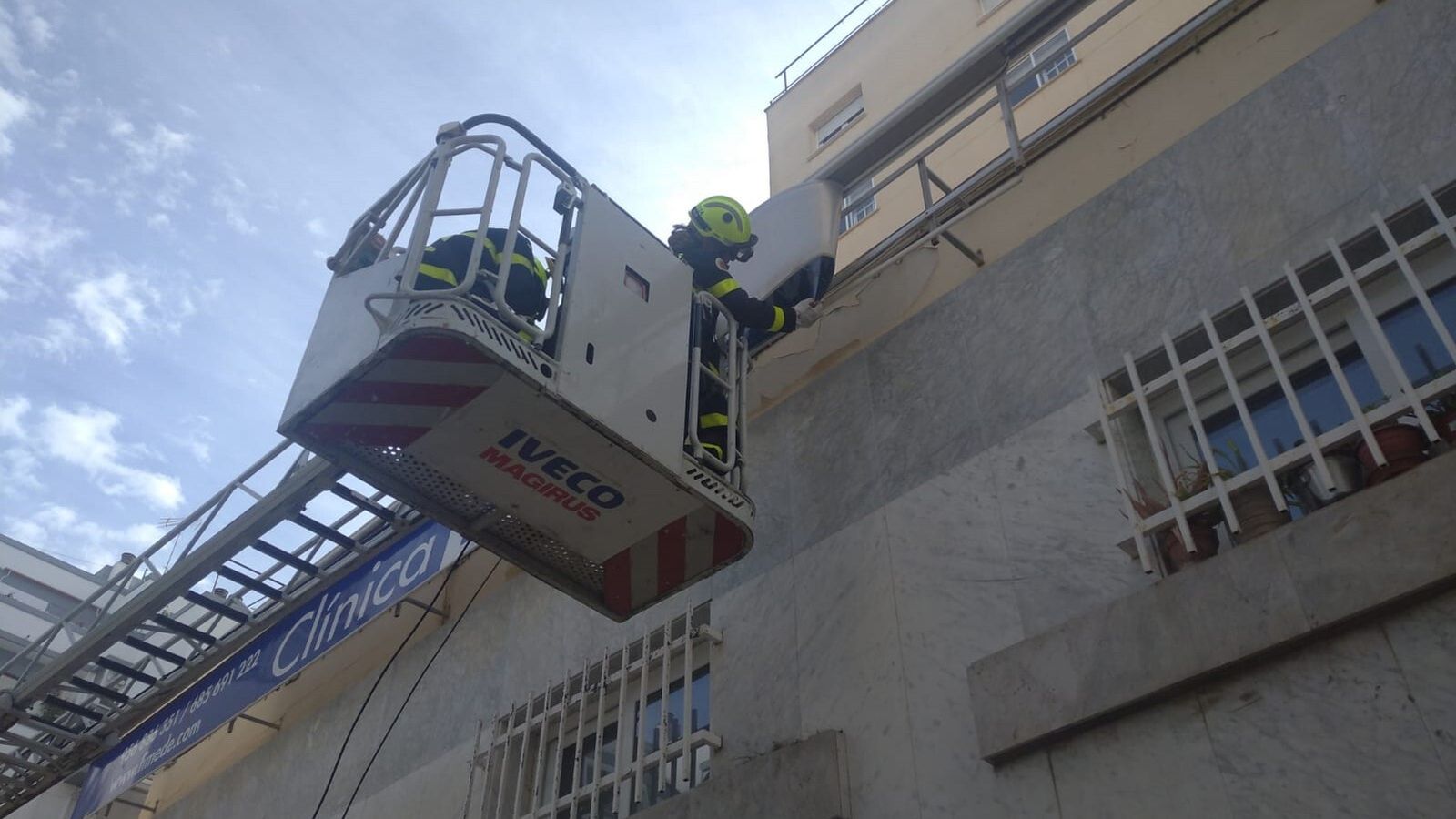 Bomberos intervienen en la retirada de un cartel en San Fernando, una de las incidencias registradas por el fuerte viento.