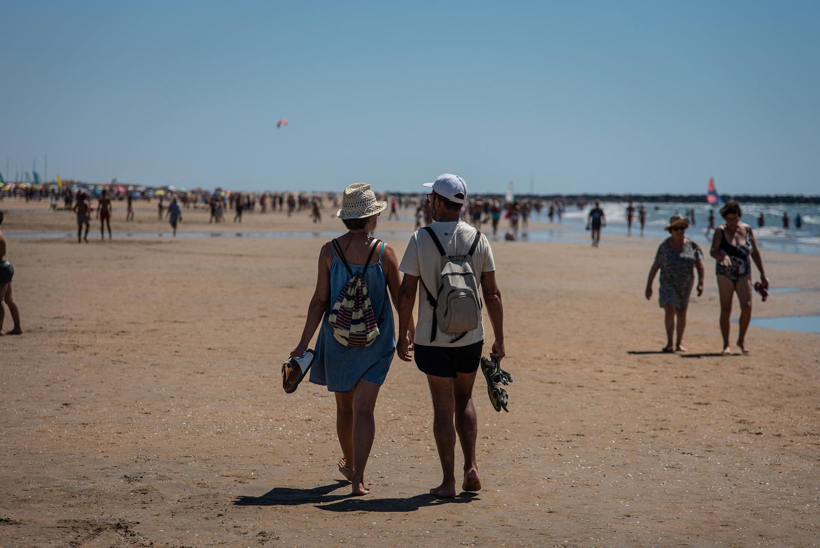 Una pareja pasea por una playa onubense.