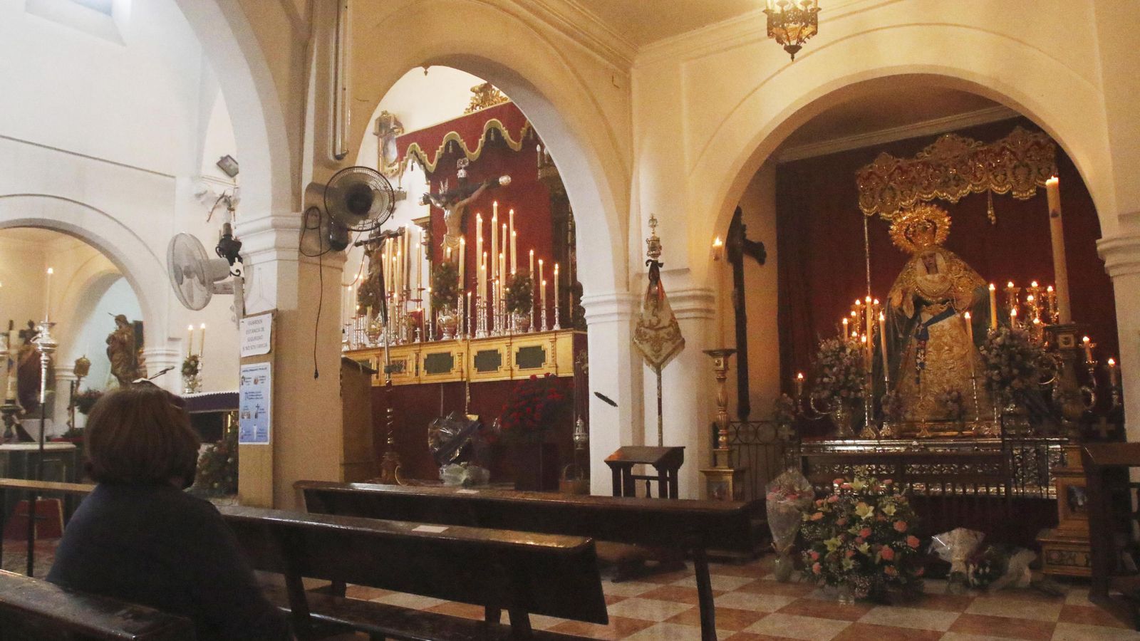 Una devota reza ante los titulares de la Agonía.