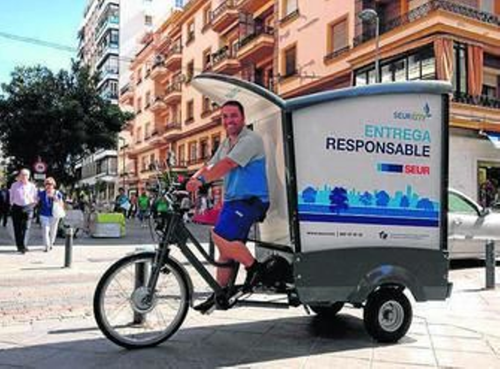 Un operario de Seur pasa por Asunción en la bicicleta de reparto.