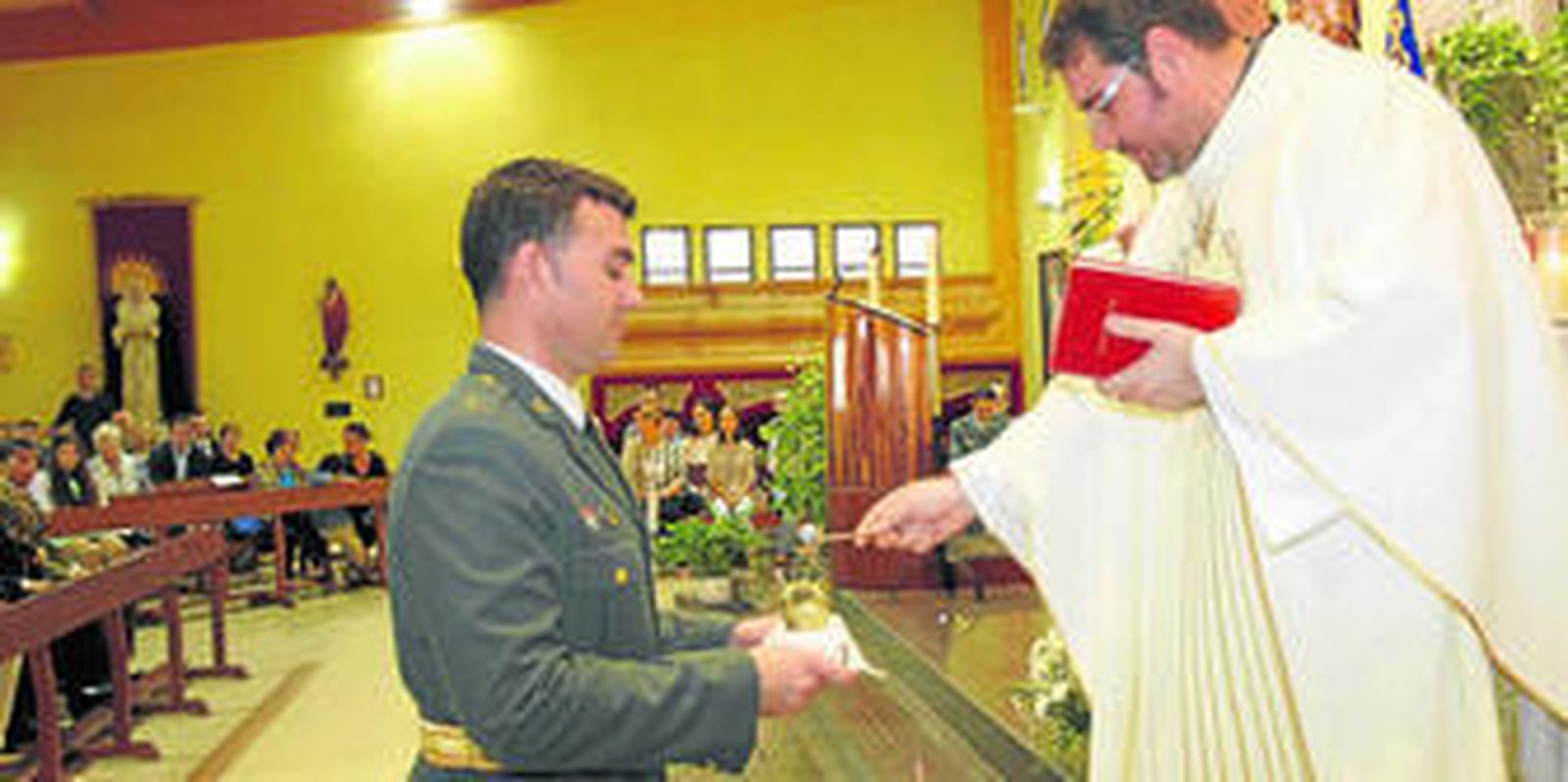 El párroco bendice las coronas antes de colocarlas a la Virgen y al niño, ayer en la iglesia de Santiago.