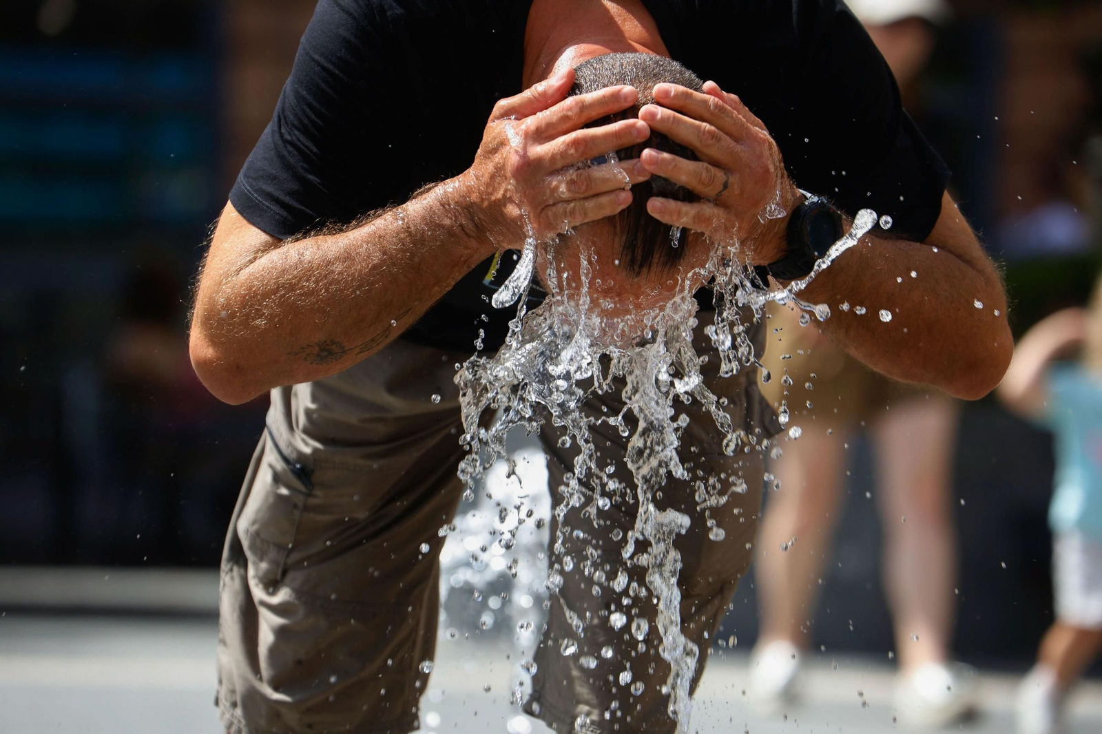 Una persona se refresca en una fuente durante esta ola de calor.