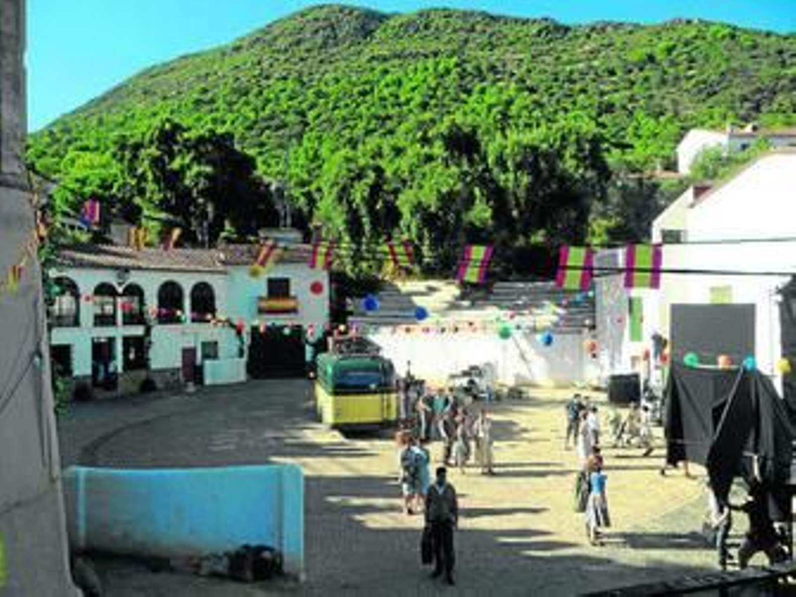 Arriba, los protagonistas atraviesan la plaza. Abajo, figurantes y actores, durante el rodaje.