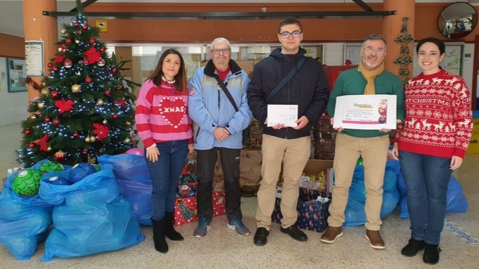Juan Dorado, director del centro y segundo por la derecha, entrega el cheque con los recaudado para la iniciativa de ‘Carta Real’ a representantes de La Clemencia. Junto a ellos, las profesoras Elena Pina y Noemí González