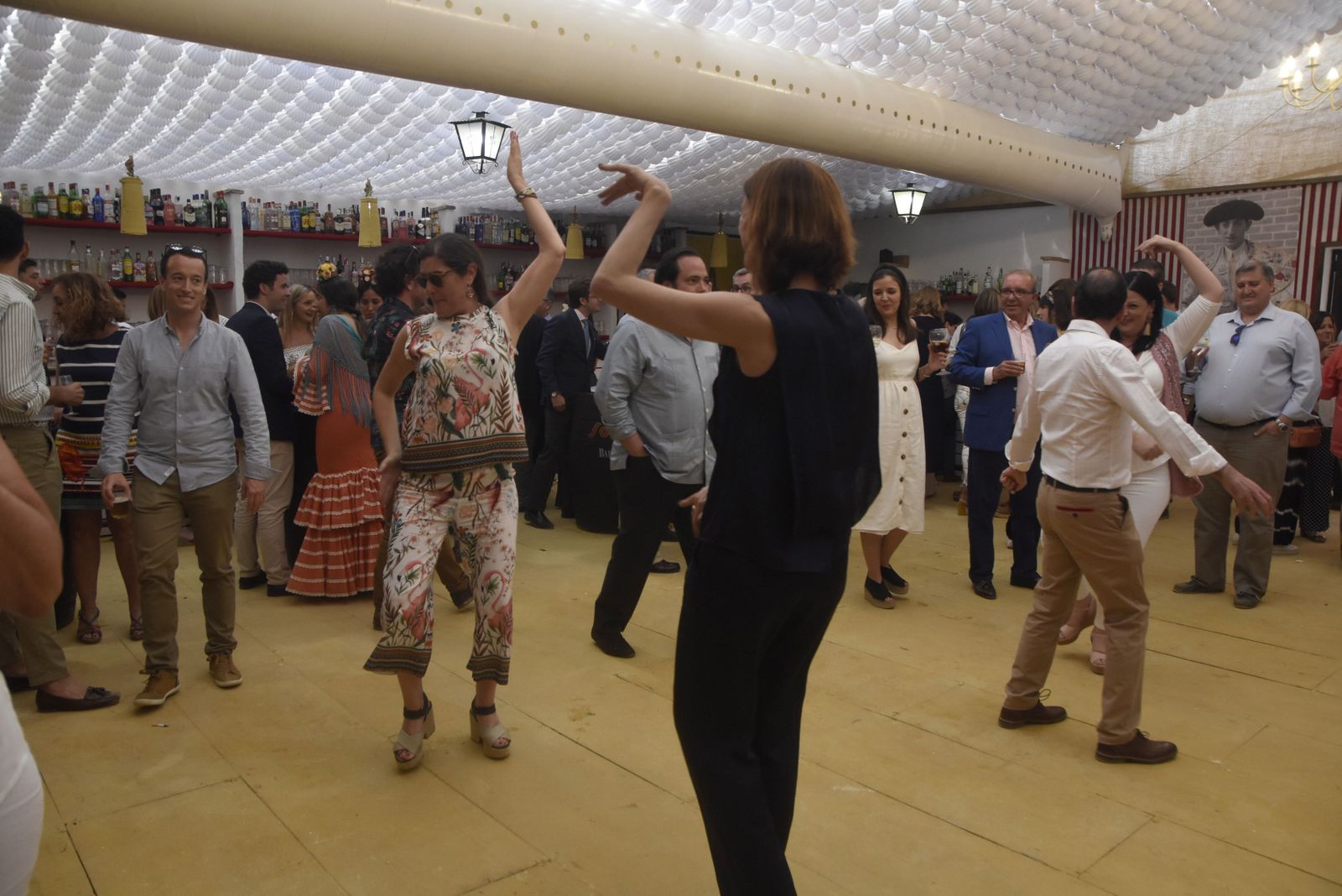 Unas mujeres bailan en una de las casetas de la Feria de Córdoba.