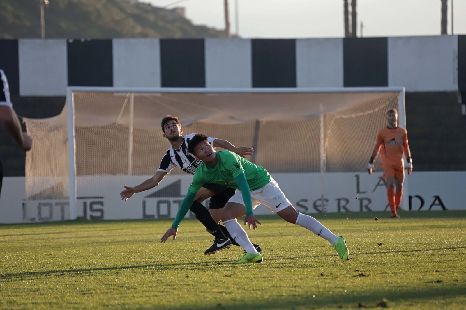 El albinegro Carrasco observa la pelota junto al rojiblanco Lin.