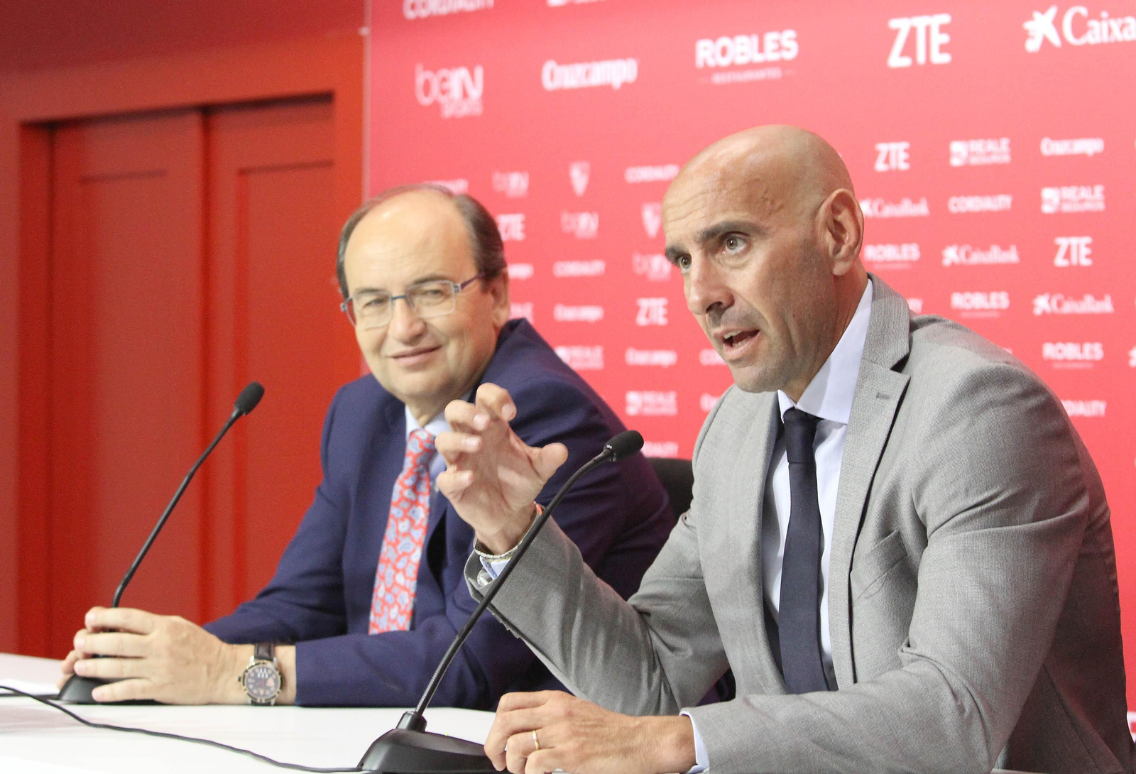 Monchi se explica en una rueda de prensa mientras José Castro lo escucha sonriente.