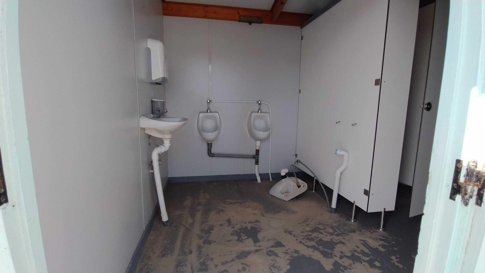 Uno de los antiguos módulos de servicios de la playa que se ha emplazado en La Casería para los pescadores, en el que todavía están los aseos.