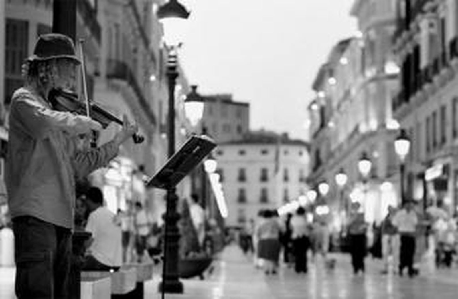 Un músico callejero toca el violín en la calle Larios de Málaga capital.