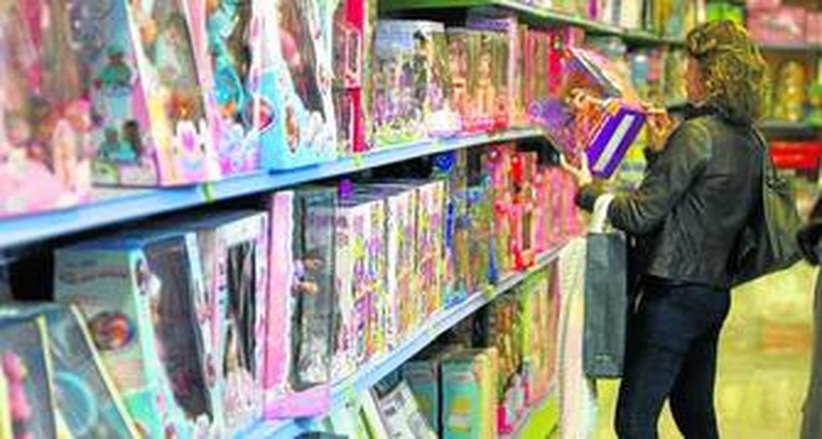 Una mujer elige un juguete en el pasillo de 'Juguetoon', en la plaza Jesús Nazareno de Cádiz.