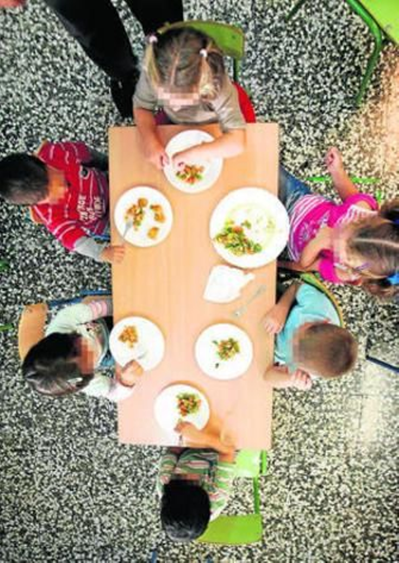 Un grupo de seis alumnos almuerzan en una de las mesas del comedor escolar.