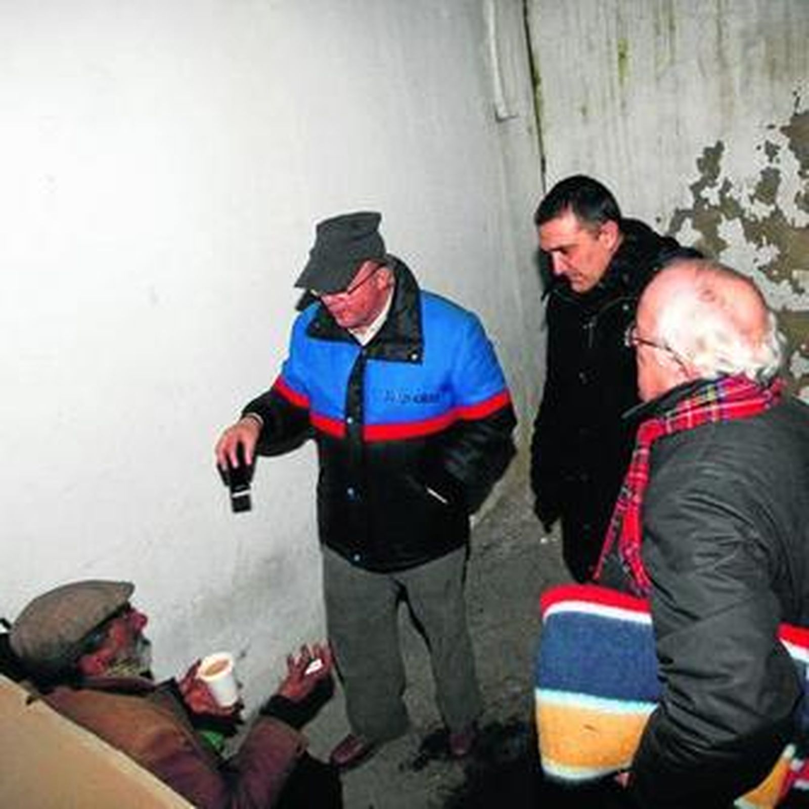 Antonio recibe el café que los voluntarios de Cáritas le ofrecen durante la noche.