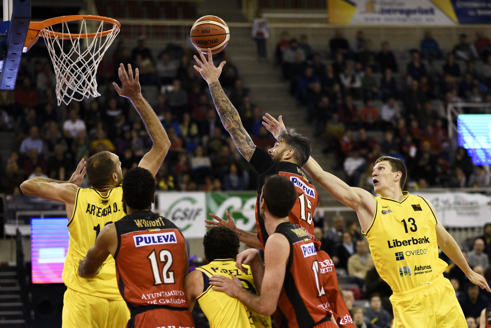 Guille Rubio lucha por la captura de un rebote entres jugadores del Covirán y el Oviedo.
