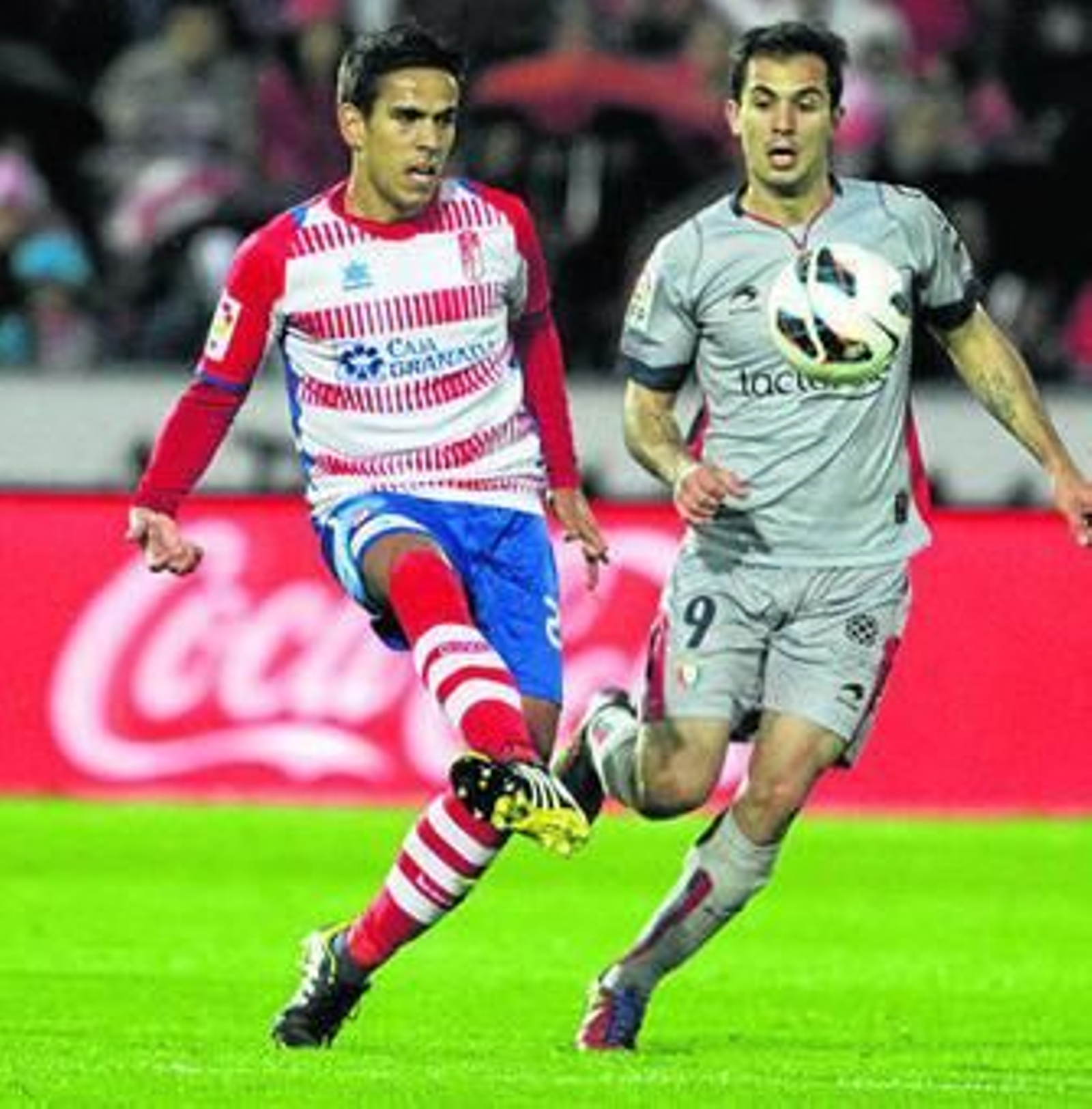 Recio golpea el cuero ante la presión del osasunista Armenteros en un encuentro en Los Cármenes.