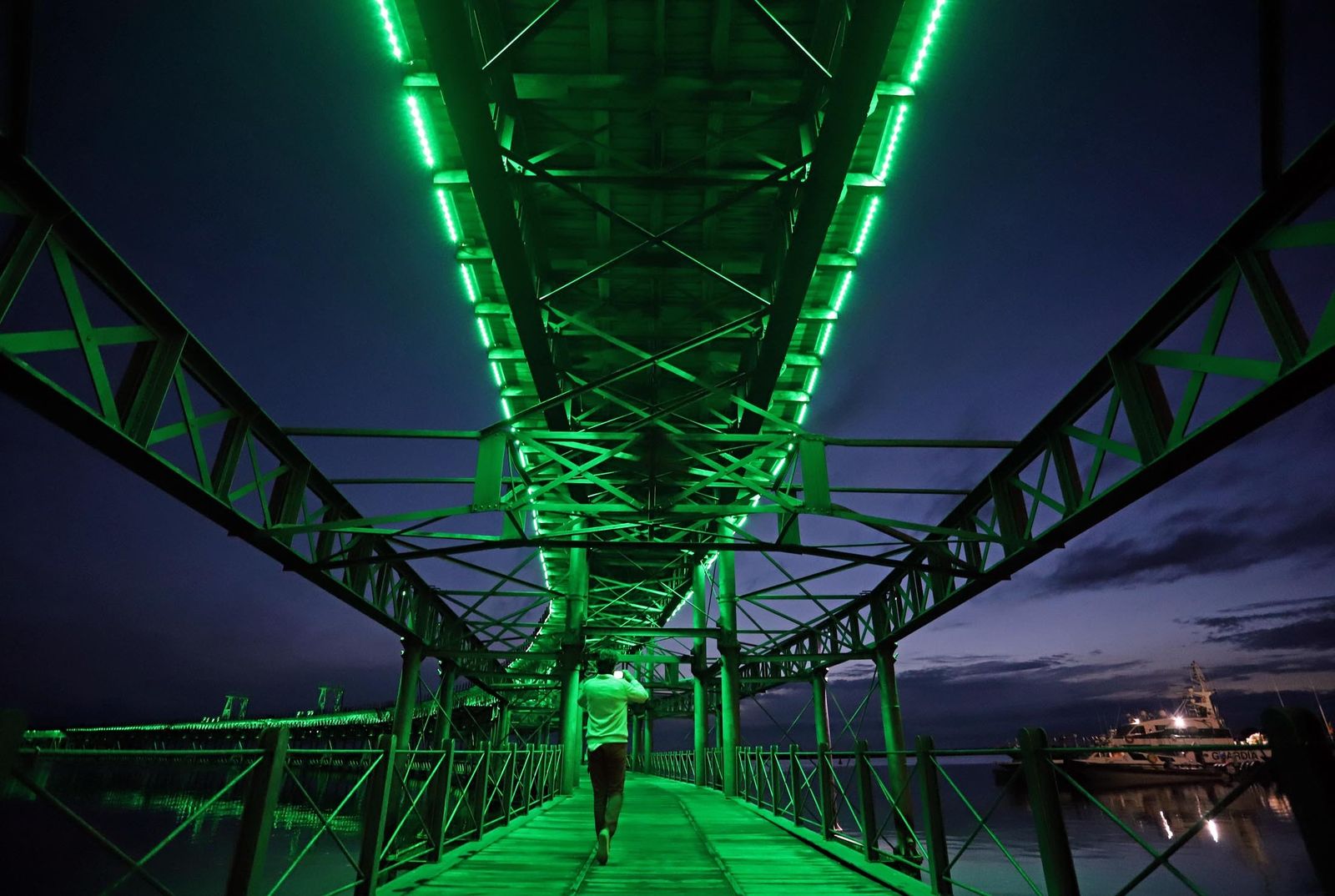 El muelle de la Riotinto se ilumina de verde en el día mundial contra el cancer