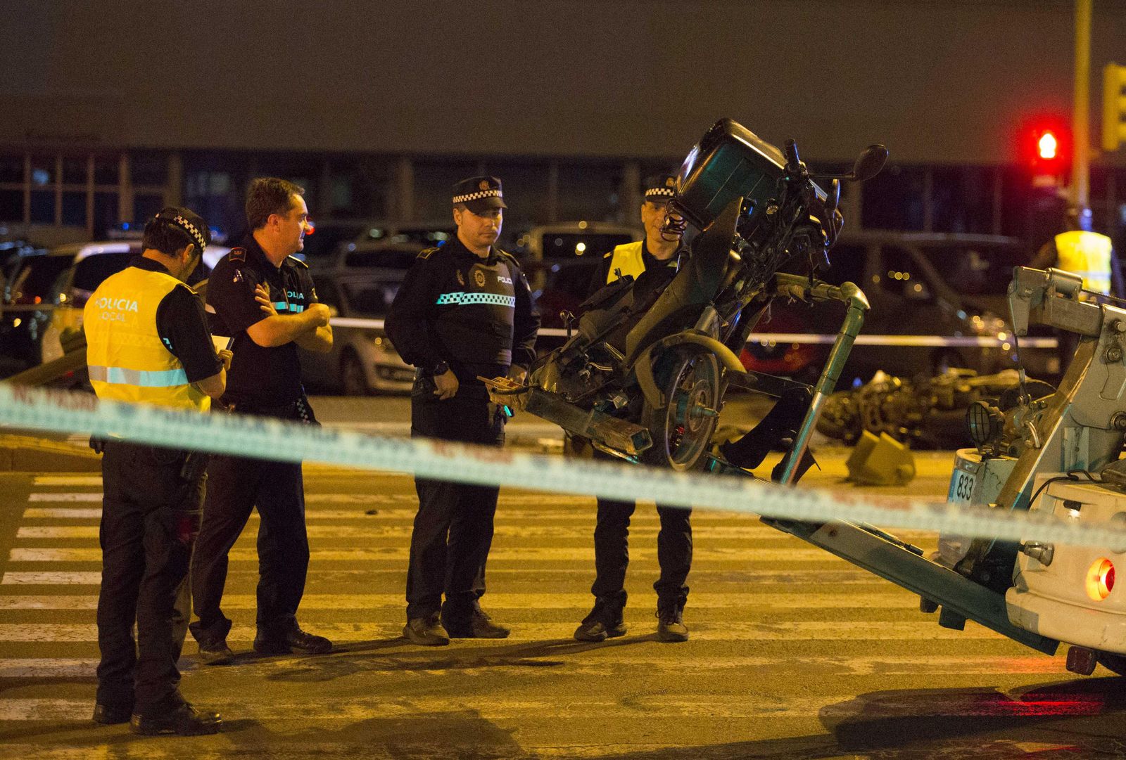 La grúa se lleva la motocicleta del repartidor, en presencia de varios agentes de Policía Local