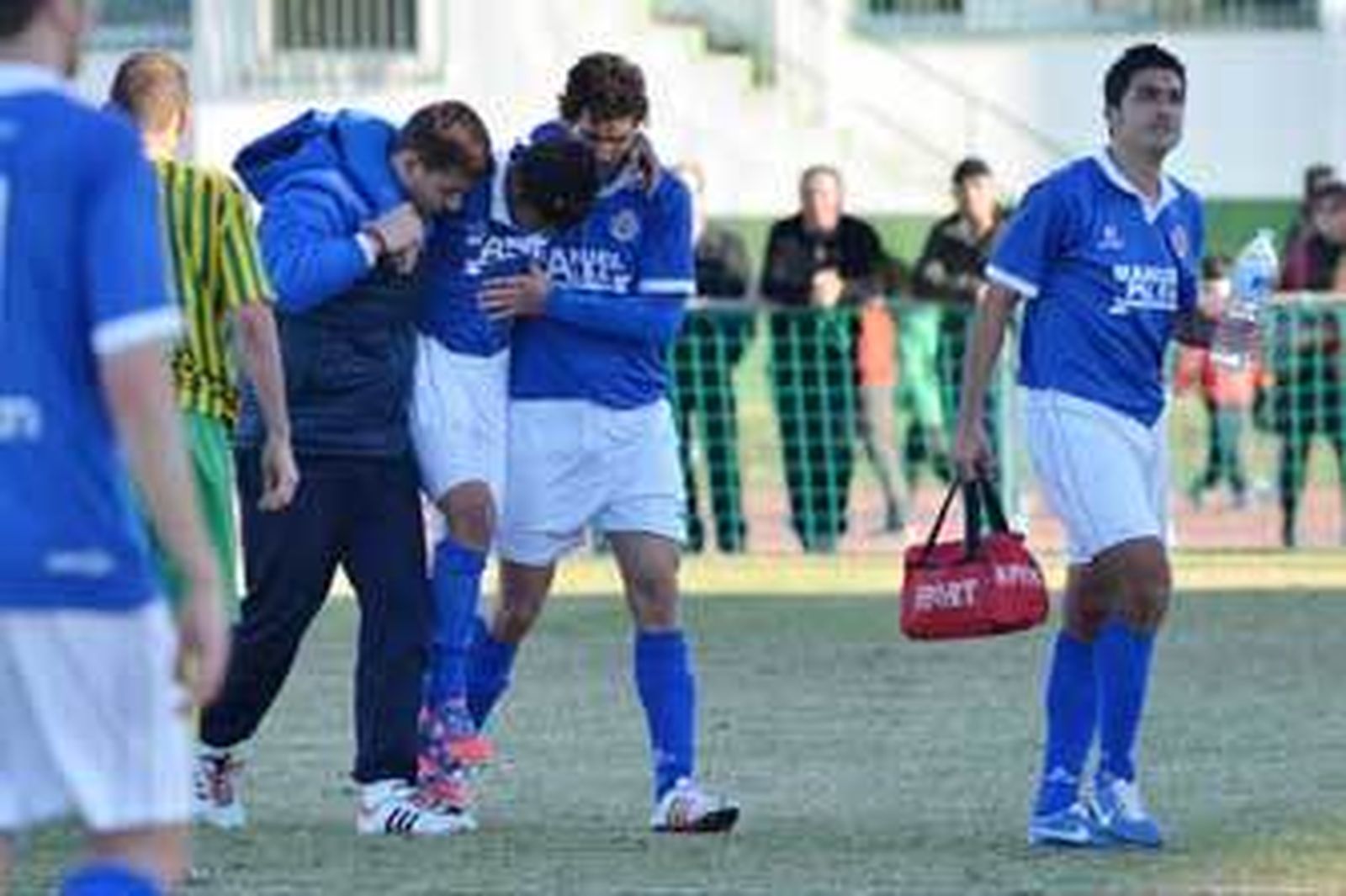 Enrique Olmo abandona el Navarro Flores ayudado por Azores y el fisio José Luis Cuenda. /Manuel Aranda