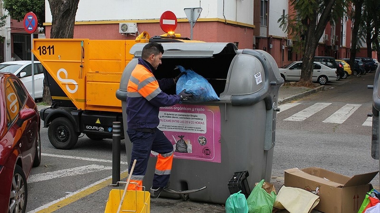 Operario de Lipasam recoge la basura depositada fuera del contenedor.