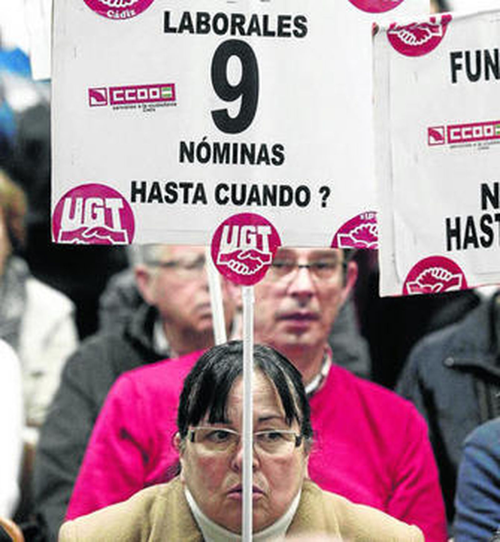 Asistentes al último Pleno municipal de La Línea muestran carteles donde recuerdan los impagos.
