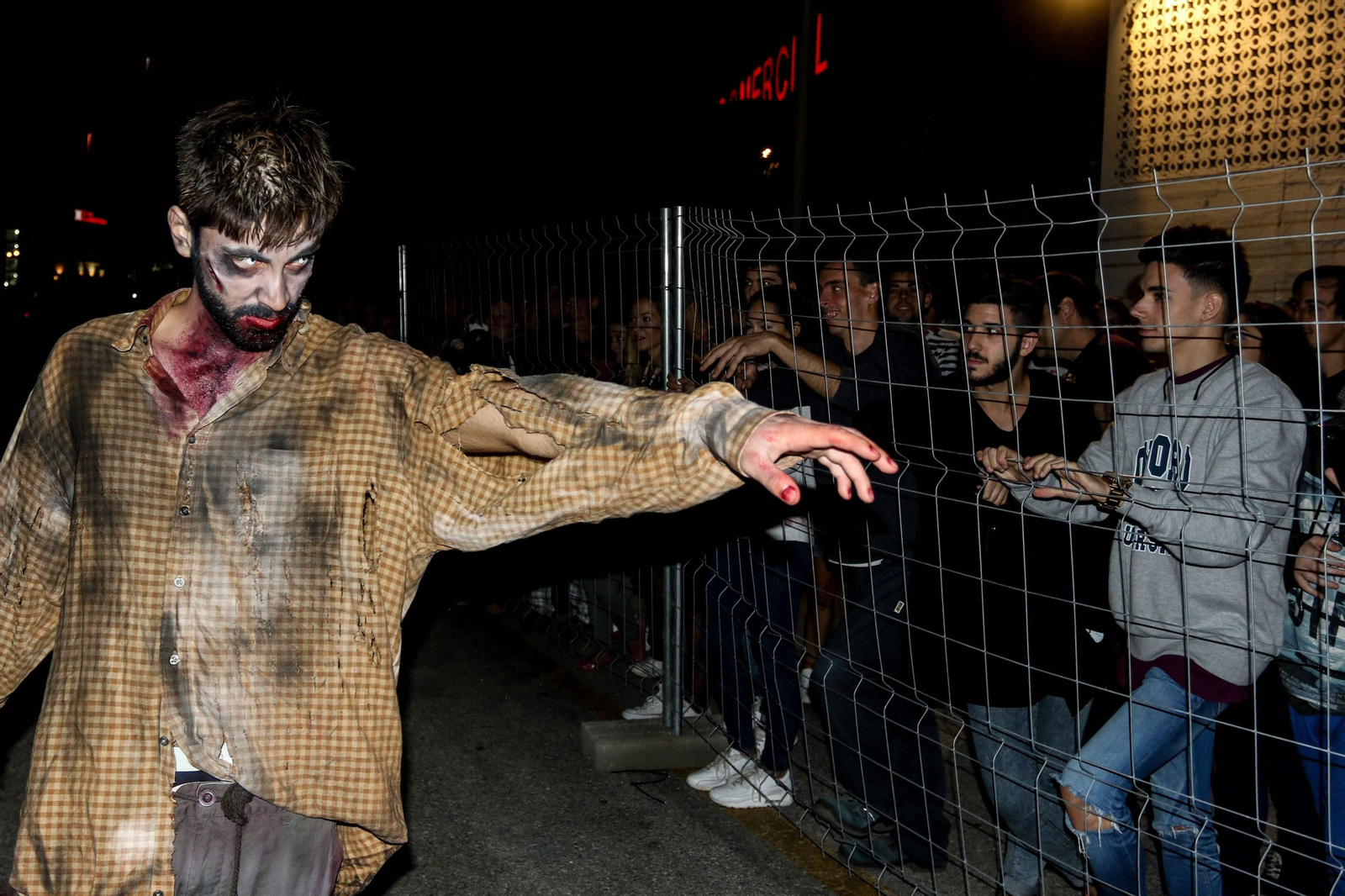 Una persona caracterizada de zombie atemoriza a los asistentes.