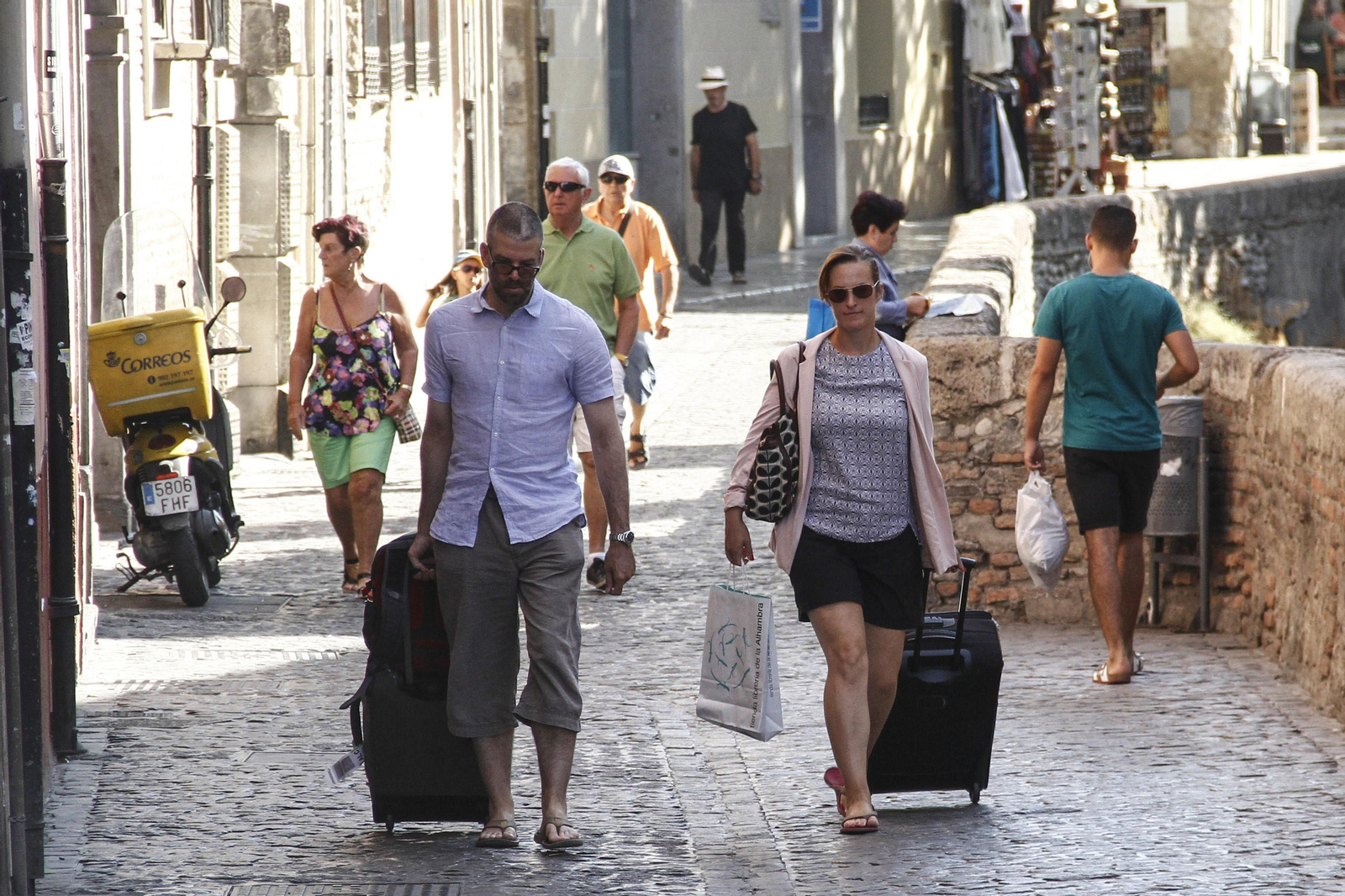 Una pareja de turistas pasea por la Carrera del Darro de Granada